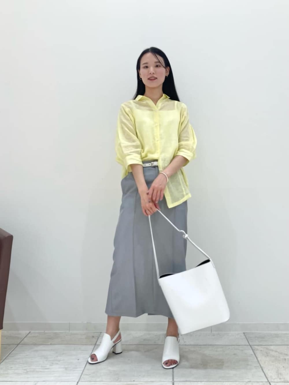 ホワイト系のショルダーバッグ、グレー系のスカート、ホワイト系のサンダルを着用したレディースの夏コーディネートの1枚目の写真