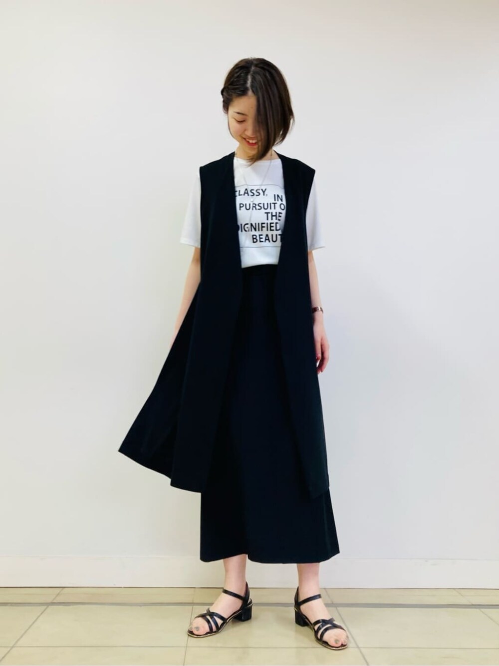 ホワイト系のTシャツ/カットソー、ブラック系のベスト、ブラック系のスカートを着用したレディースの夏コーディネートの1枚目の写真