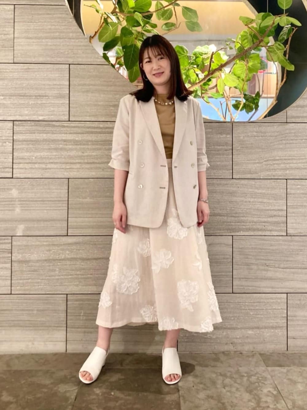 イエロー系のTシャツ/カットソー、ホワイト系のサンダル、ベージュ系のテーラードジャケットを着用したレディースの春コーディネートの1枚目の写真