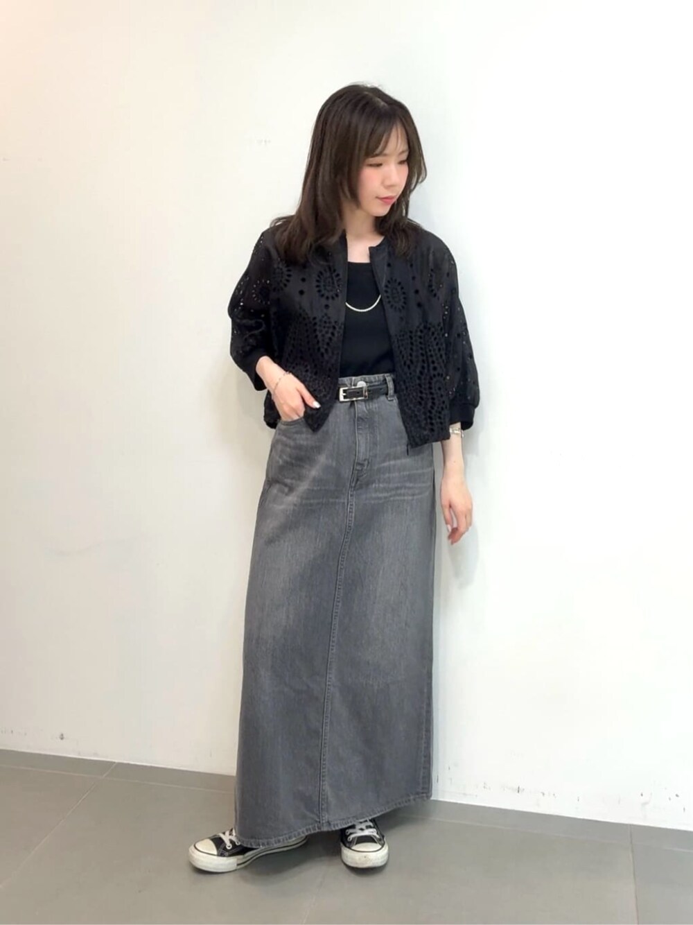 グレー系のスカート、ブラック系のタンクトップ、ブラック系のブルゾンを着用したレディースの夏コーディネートの1枚目の写真