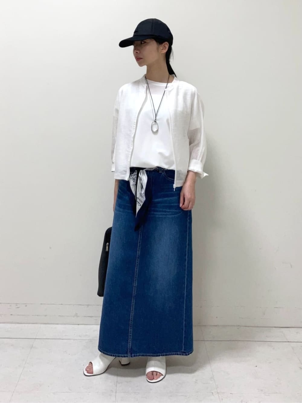 ホワイト系のサンダル、グレー系のスカート、ホワイト系のブルゾンを着用したレディースの夏コーディネートの1枚目の写真