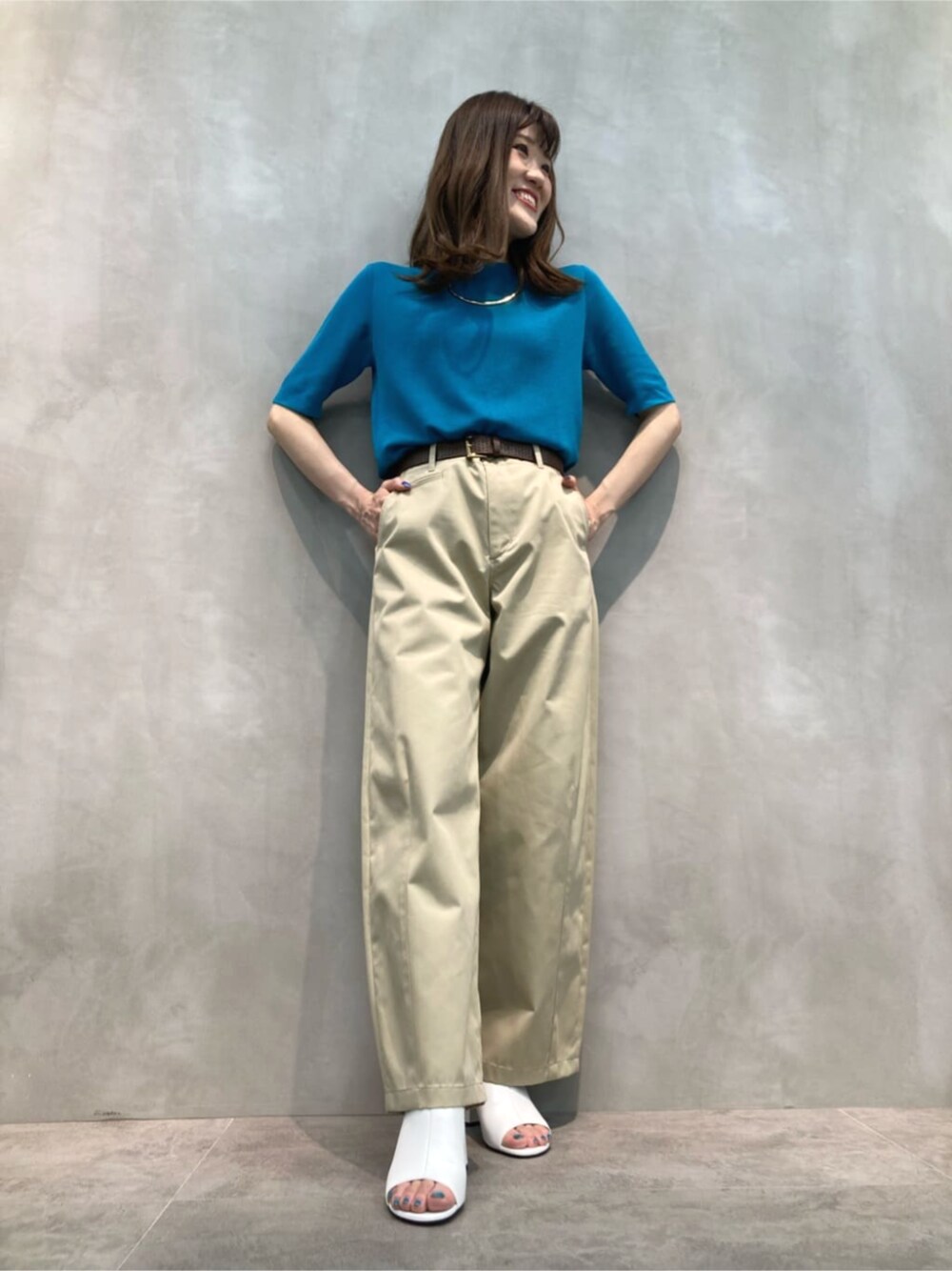 ベージュ系のチノパンツ、ホワイト系のサンダル、グリーン系のニット/セーターを着用したレディースの夏コーディネートの1枚目の写真