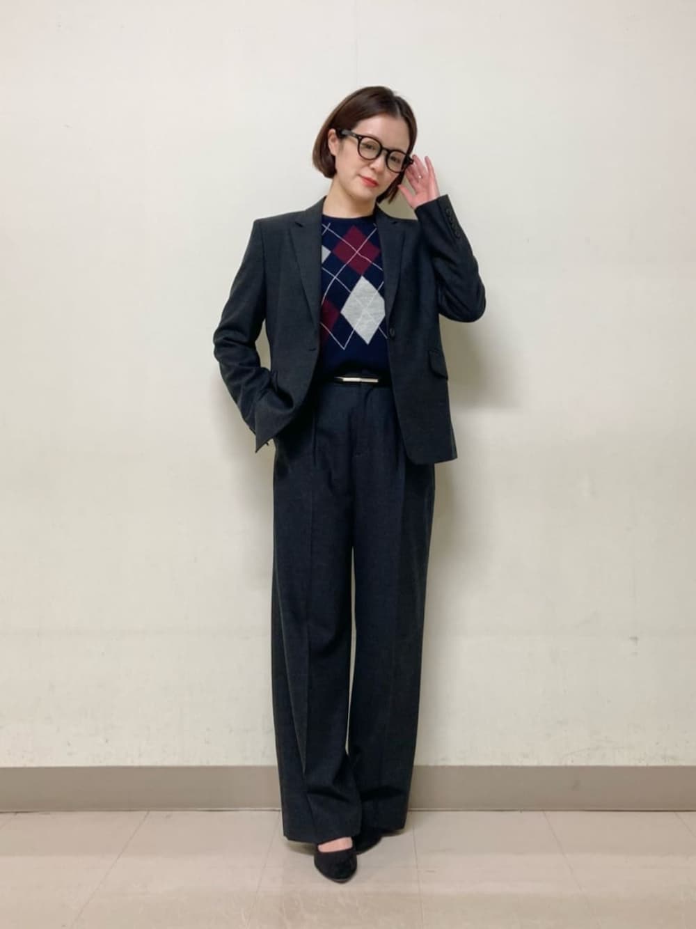 グレー系のスーツパンツ、グレー系のスーツジャケット、ブルー系のニット/セーターを着用したレディースの冬コーディネートの1枚目の写真