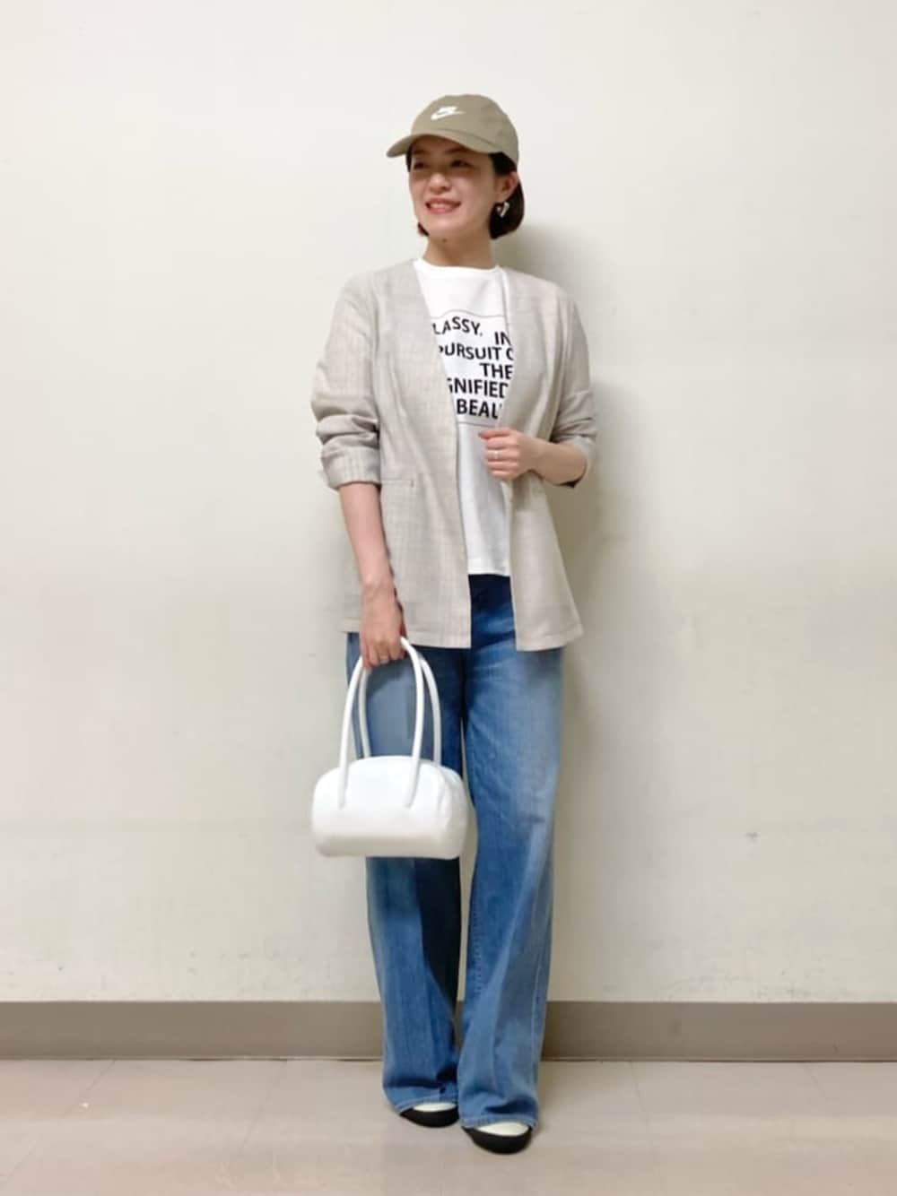 ブルー系のデニムパンツ、ホワイト系のTシャツ/カットソー、ホワイト系のノーカラージャケットを着用したレディースの夏コーディネートの1枚目の写真