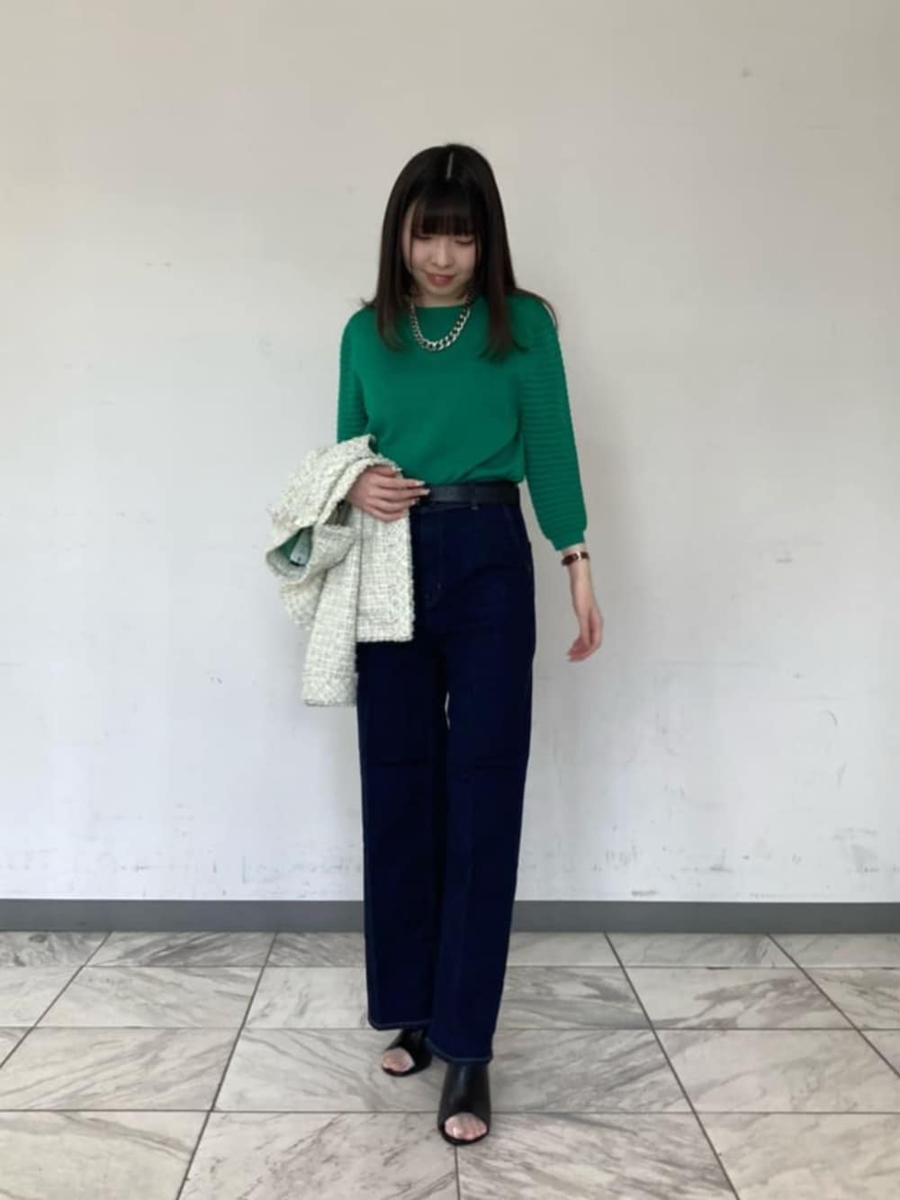 ブルー系のデニムパンツ、グリーン系のニット/セーター、ブラック系のサンダルを着用したレディースの春コーディネートの1枚目の写真