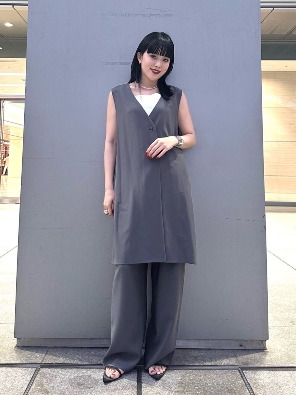 グレー系のベスト、グレー系のパンツを着用したレディースの夏コーディネートの1枚目の写真