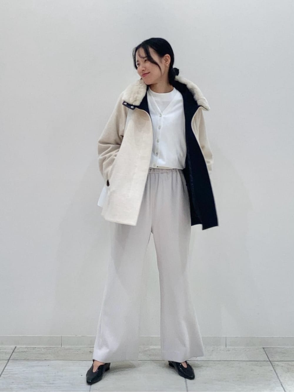 ホワイト系のその他アウター、ブラック系のその他パンツ、ホワイト系のカーディガン/ボレロを着用したレディースの冬コーディネートの1枚目の写真