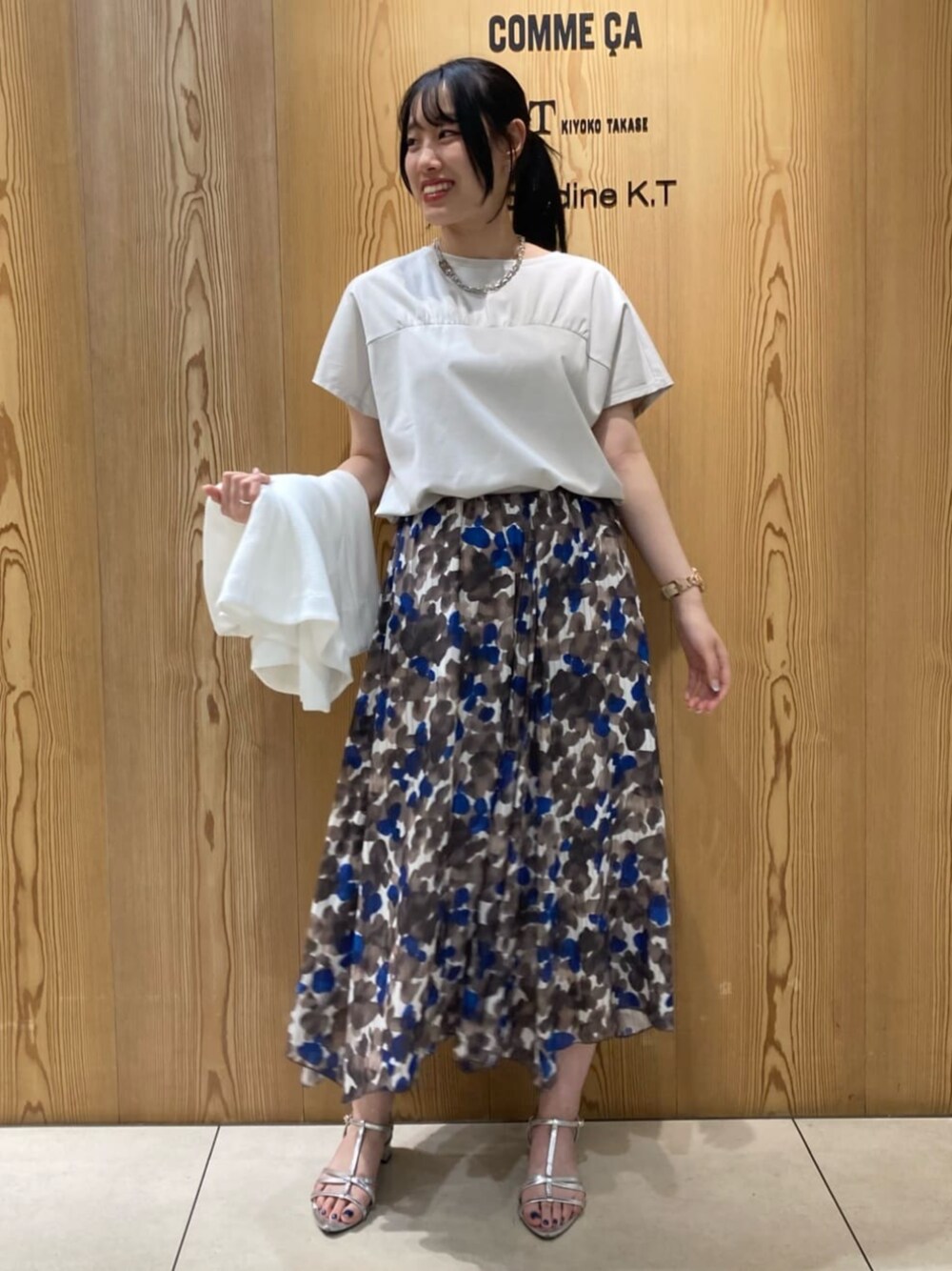 ブラウン系のスカート、ベージュ系のTシャツ/カットソーを着用したレディースの夏コーディネートの1枚目の写真