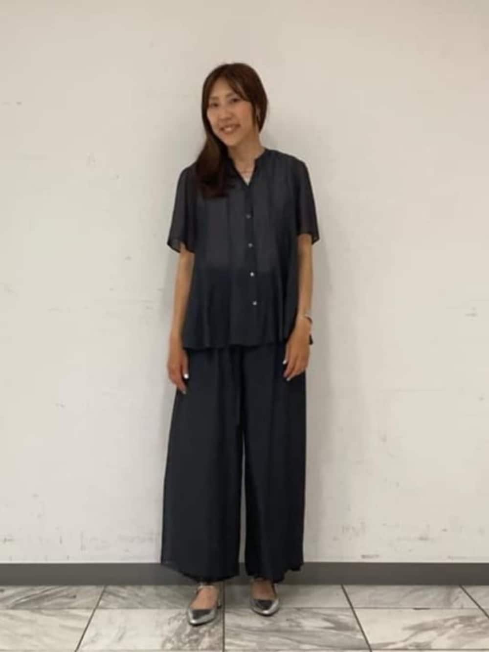 グレー系のシャツ/ブラウス、ブラック系のその他パンツ、シルバー系のバングル/リストバンドを着用したレディースの春コーディネートの1枚目の写真