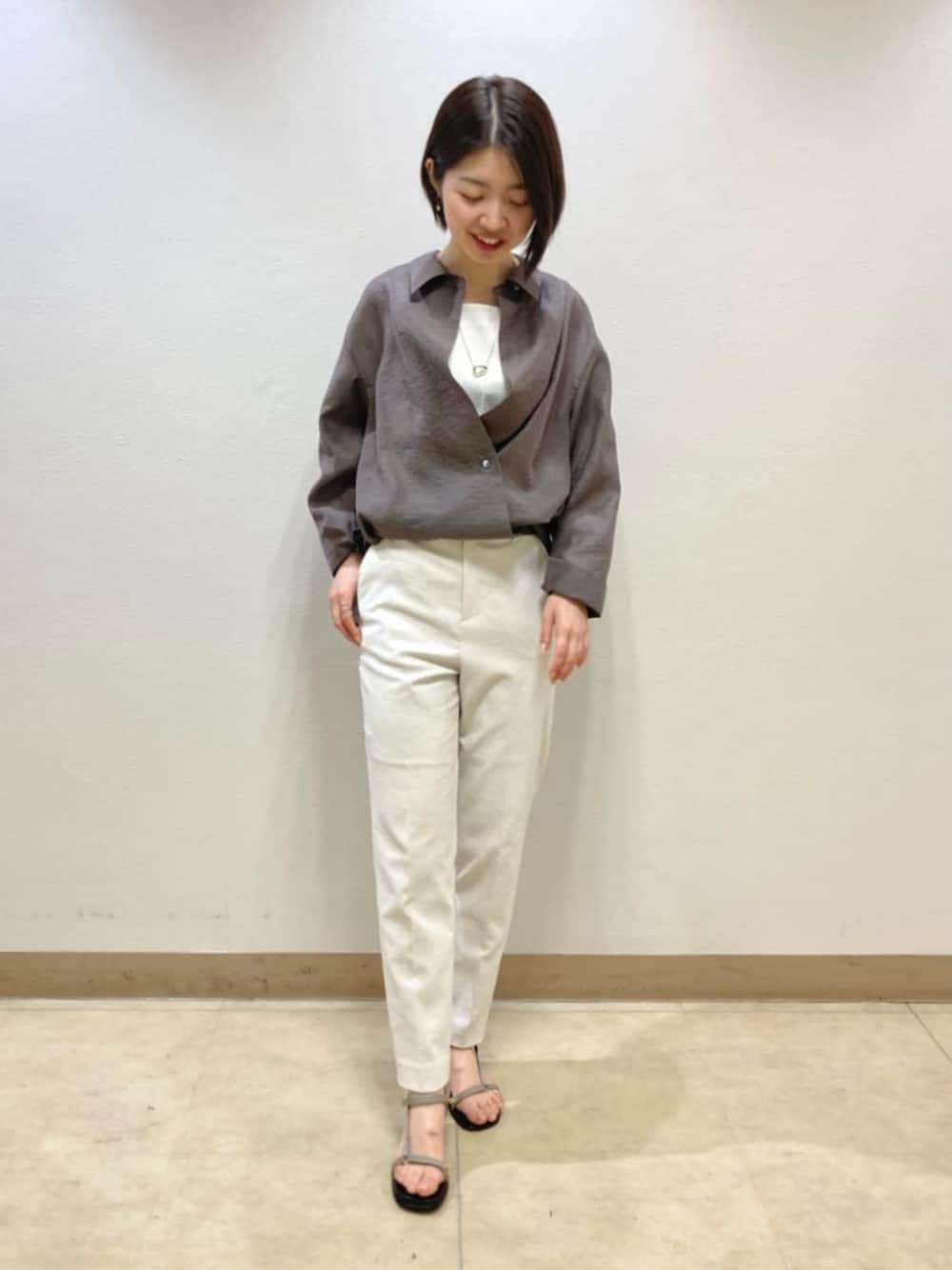ブラウン系のシャツ/ブラウス、ホワイト系のその他パンツを着用したレディースの春コーディネートの1枚目の写真