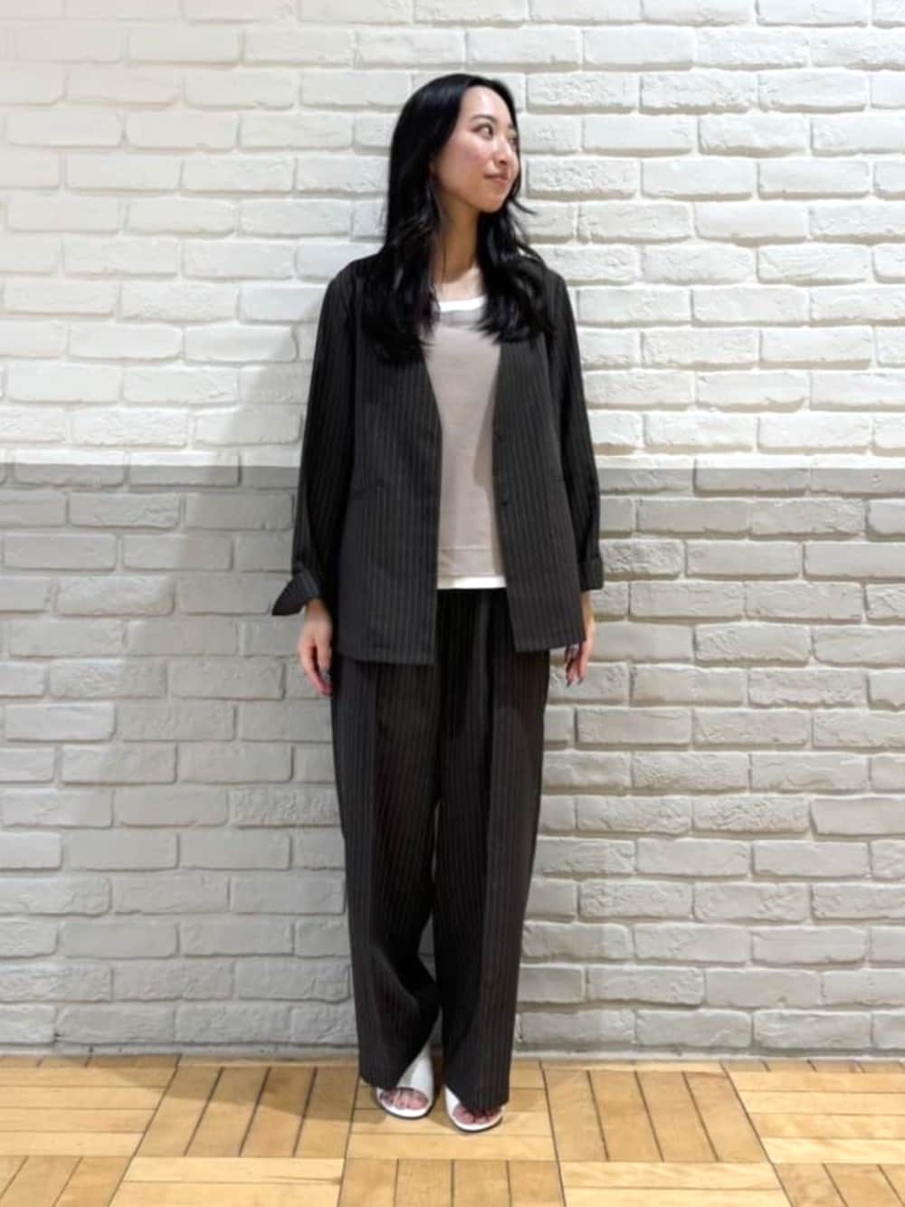 ホワイト系のサンダル、ベージュ系のタンクトップ、ブラウン系のノーカラージャケットを着用したレディースの夏コーディネートの1枚目の写真