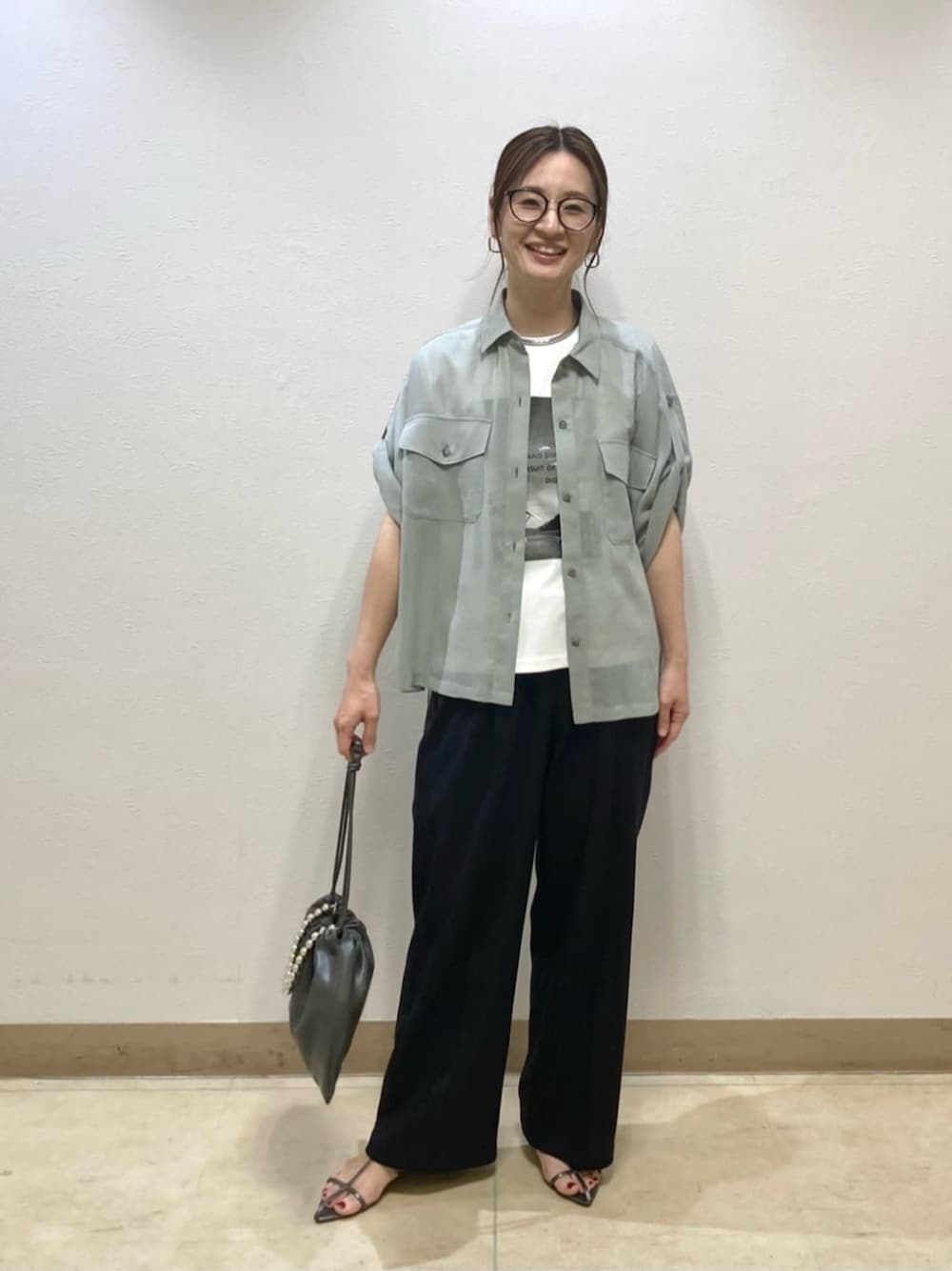 グレー系のシャツ/ブラウス、ブルー系のその他パンツ、グレー系のクラッチバッグを着用したレディースの夏コーディネートの1枚目の写真