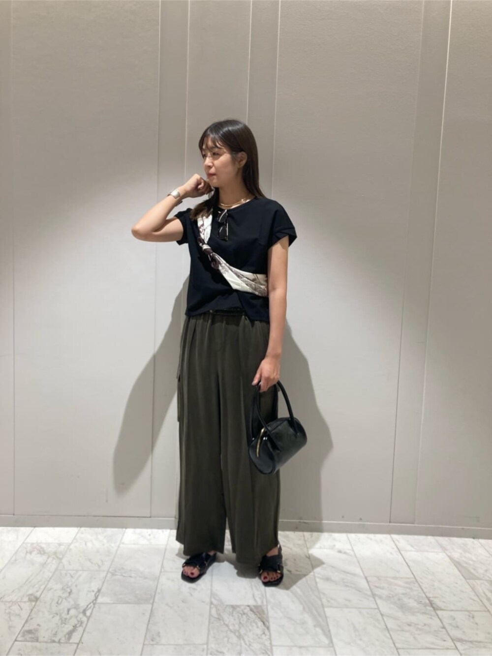 グリーン系のその他パンツ、ブラック系のTシャツ/カットソー、ブラウン系のストール/ショールを着用したレディースの秋コーディネートの1枚目の写真