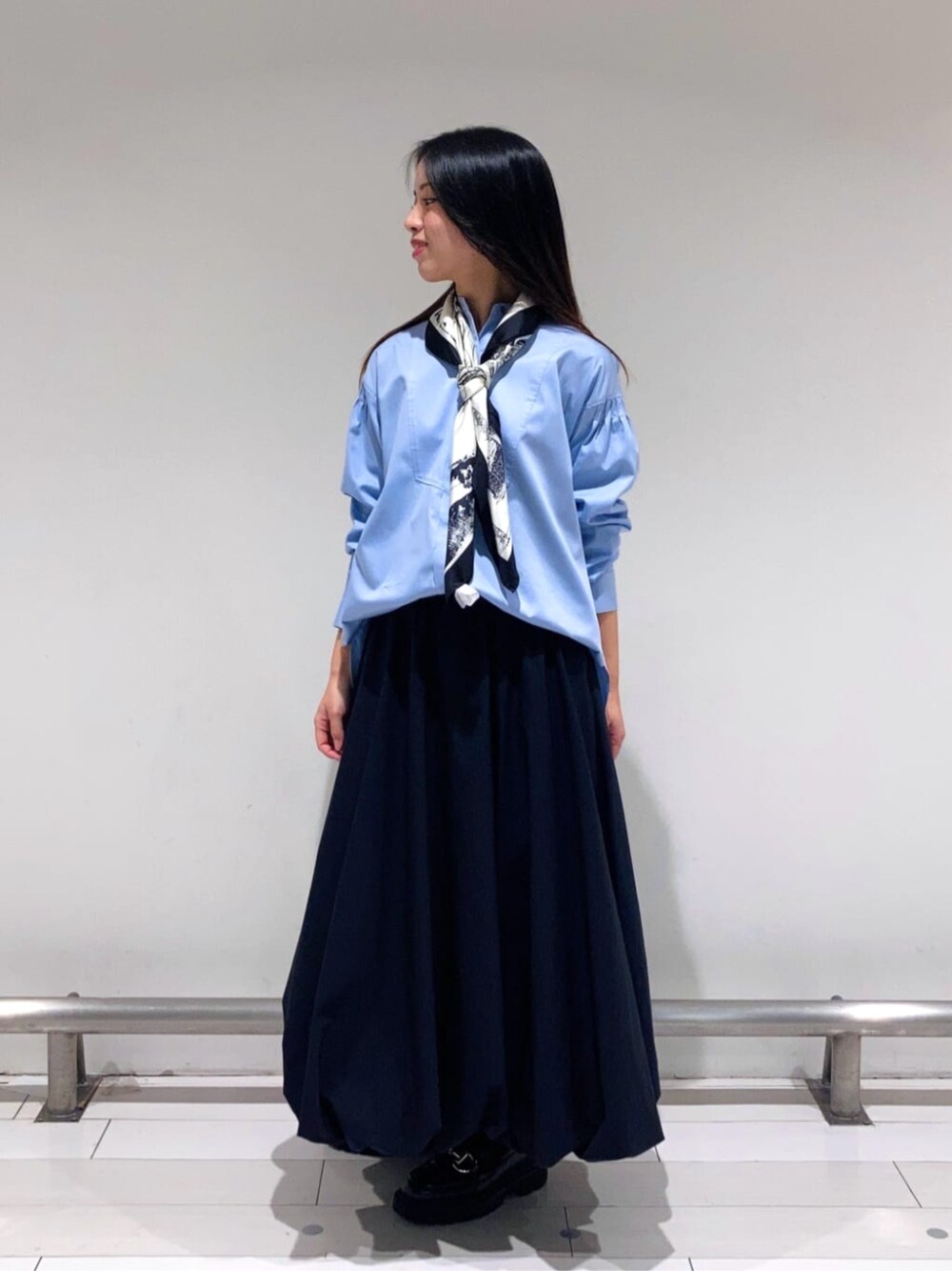 ブラック系のスカート、ブルー系のシャツ/ブラウス、ブラック系のストール/ショールを着用したレディースの春コーディネートの1枚目の写真