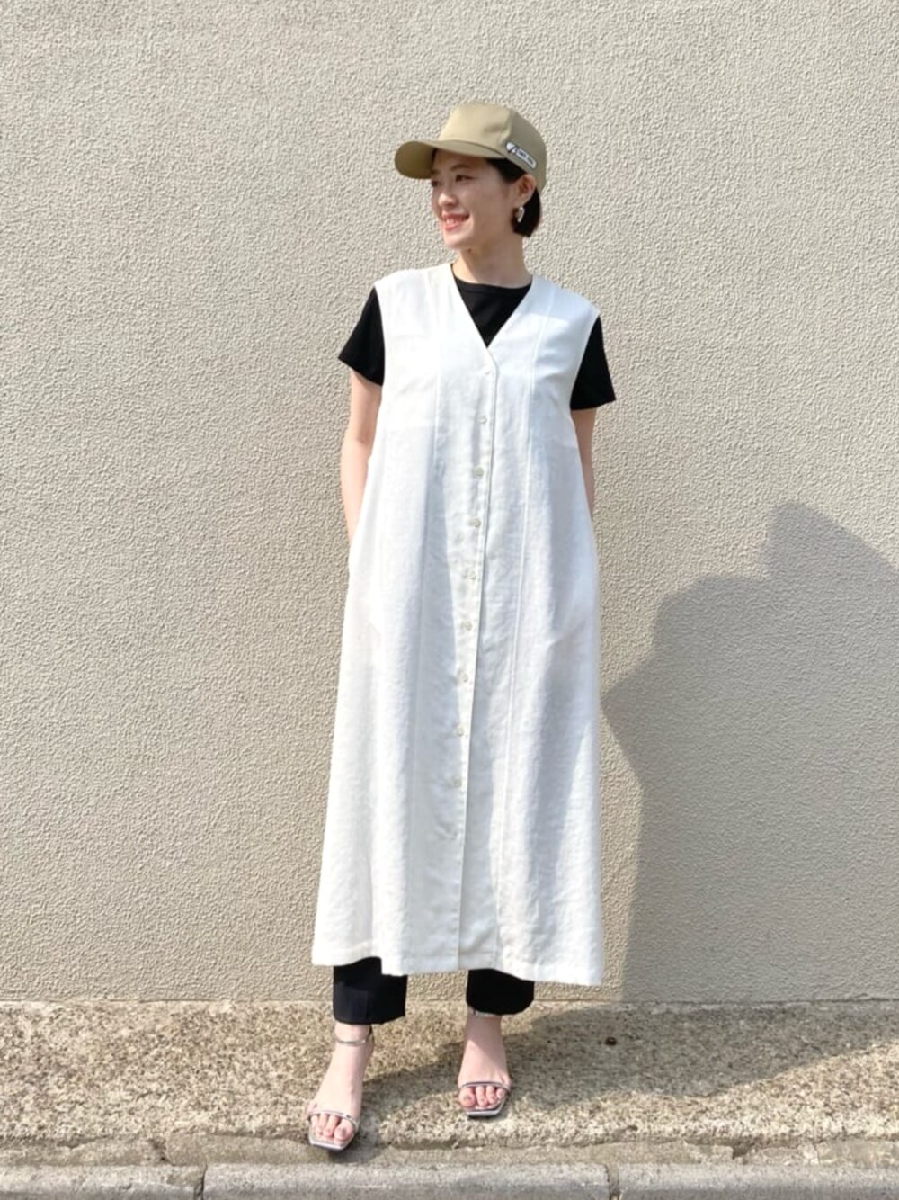 ホワイト系のトップス、ブラック系のTシャツ/カットソー、ブラック系のパンツを着用したレディースの春コーディネートの1枚目の写真