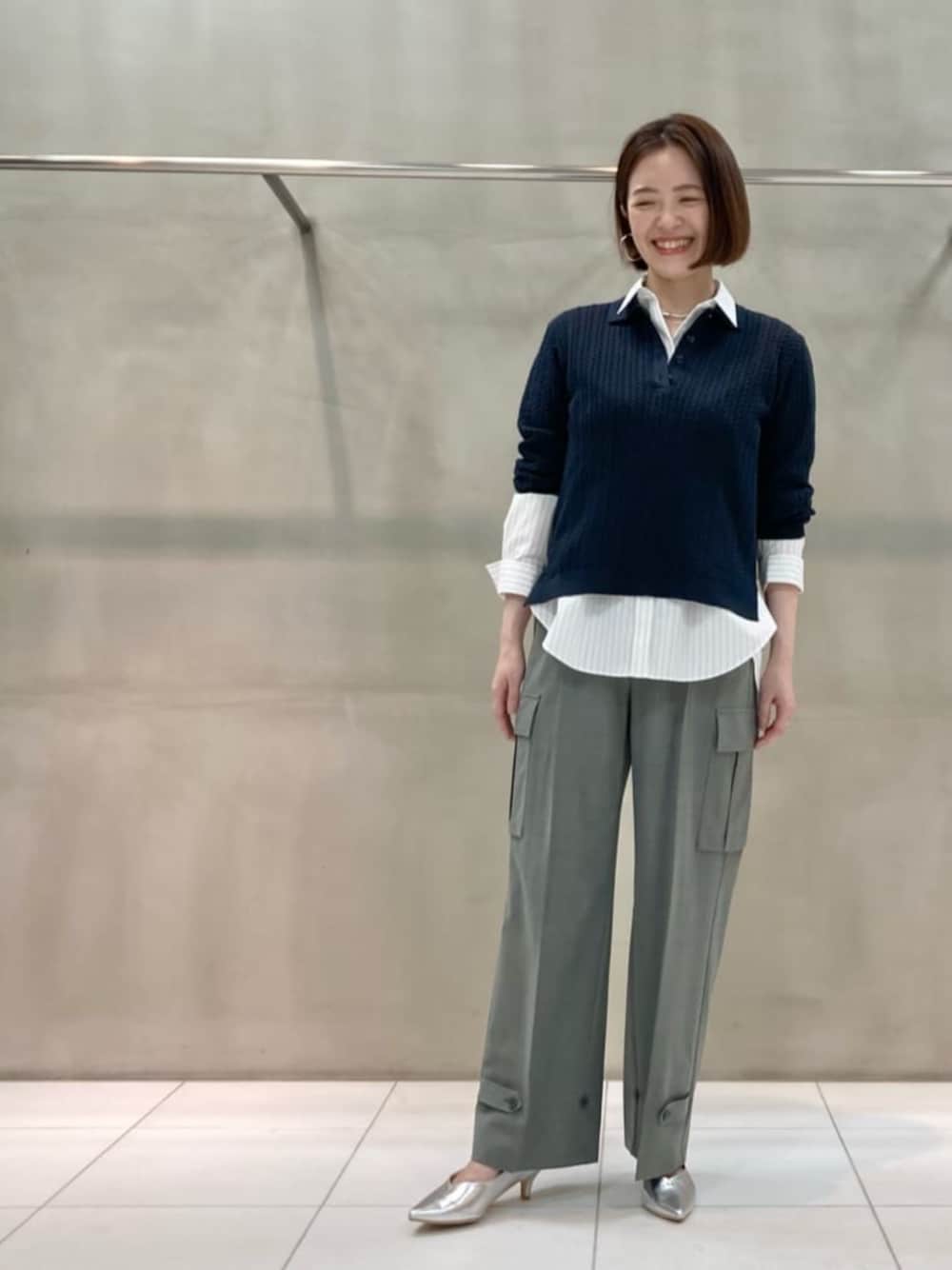 ブルー系のニット/セーター、ホワイト系のシャツ/ブラウス、グレー系のカーゴパンツを着用したレディースの夏コーディネートの1枚目の写真