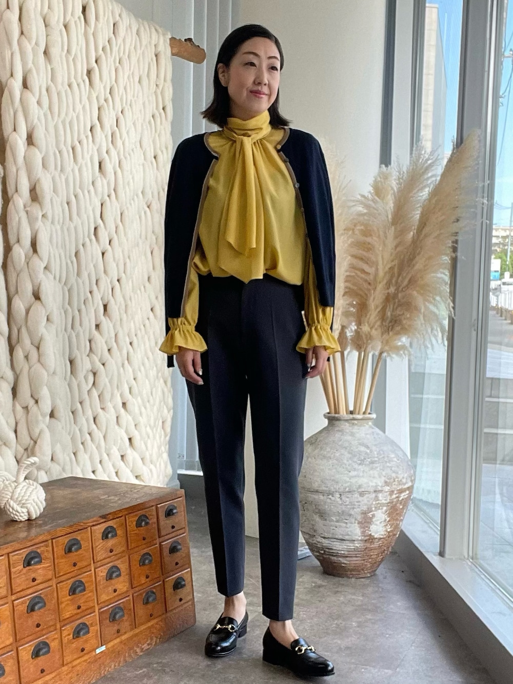 イエロー系のシャツ/ブラウス、ブルー系のカーディガン/ボレロ、グレー系のパンツを着用したレディースの夏コーディネートの1枚目の写真