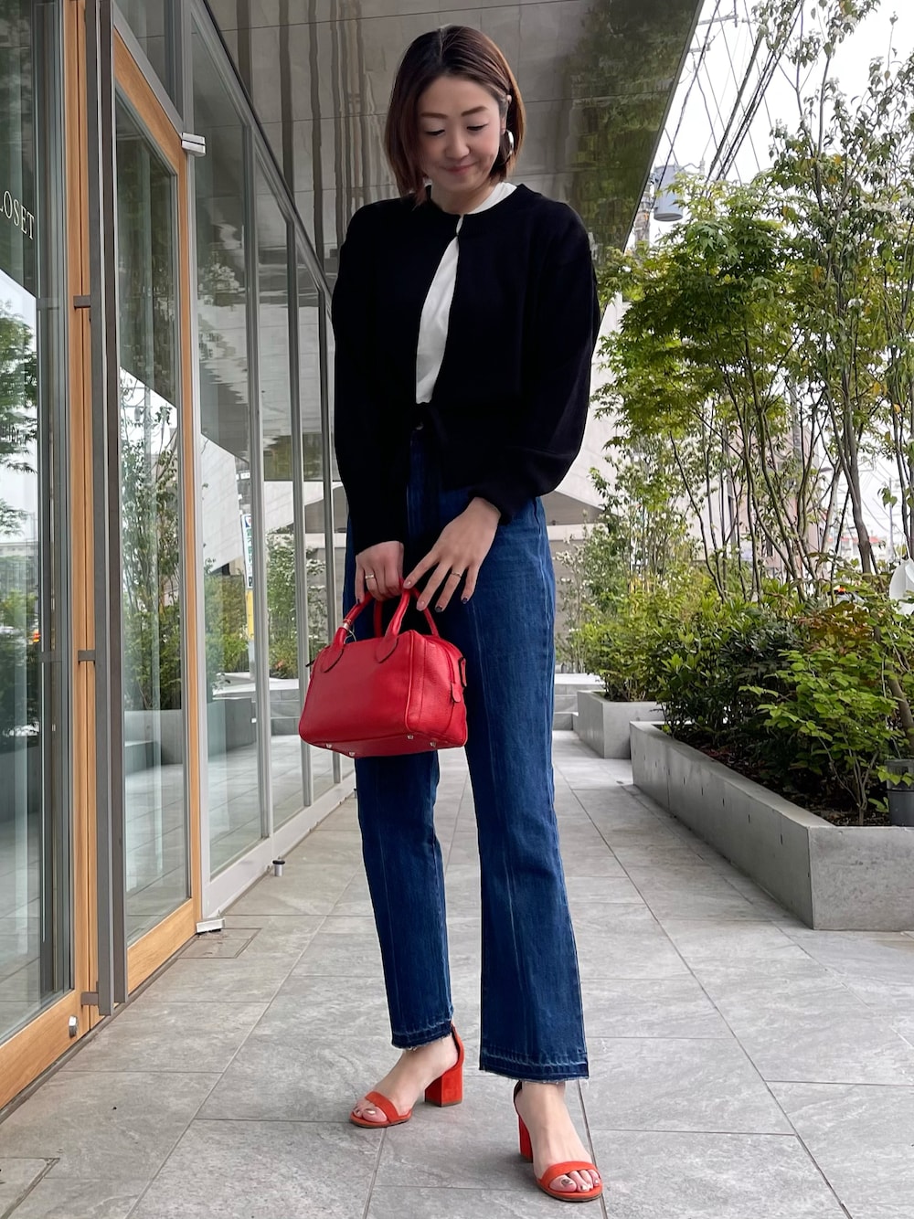 ブラック系のカーディガン/ボレロ、ブルー系のデニムパンツ、ホワイト系のTシャツ/カットソーを着用したレディースの春コーディネートの1枚目の写真