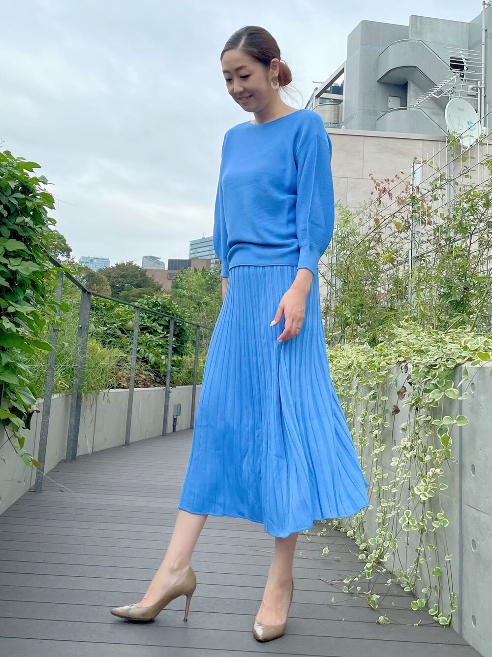 ブルー系のニット/セーター、ブルー系のスカート、ブルー系のスカートを着用したレディースの秋コーディネートの1枚目の写真