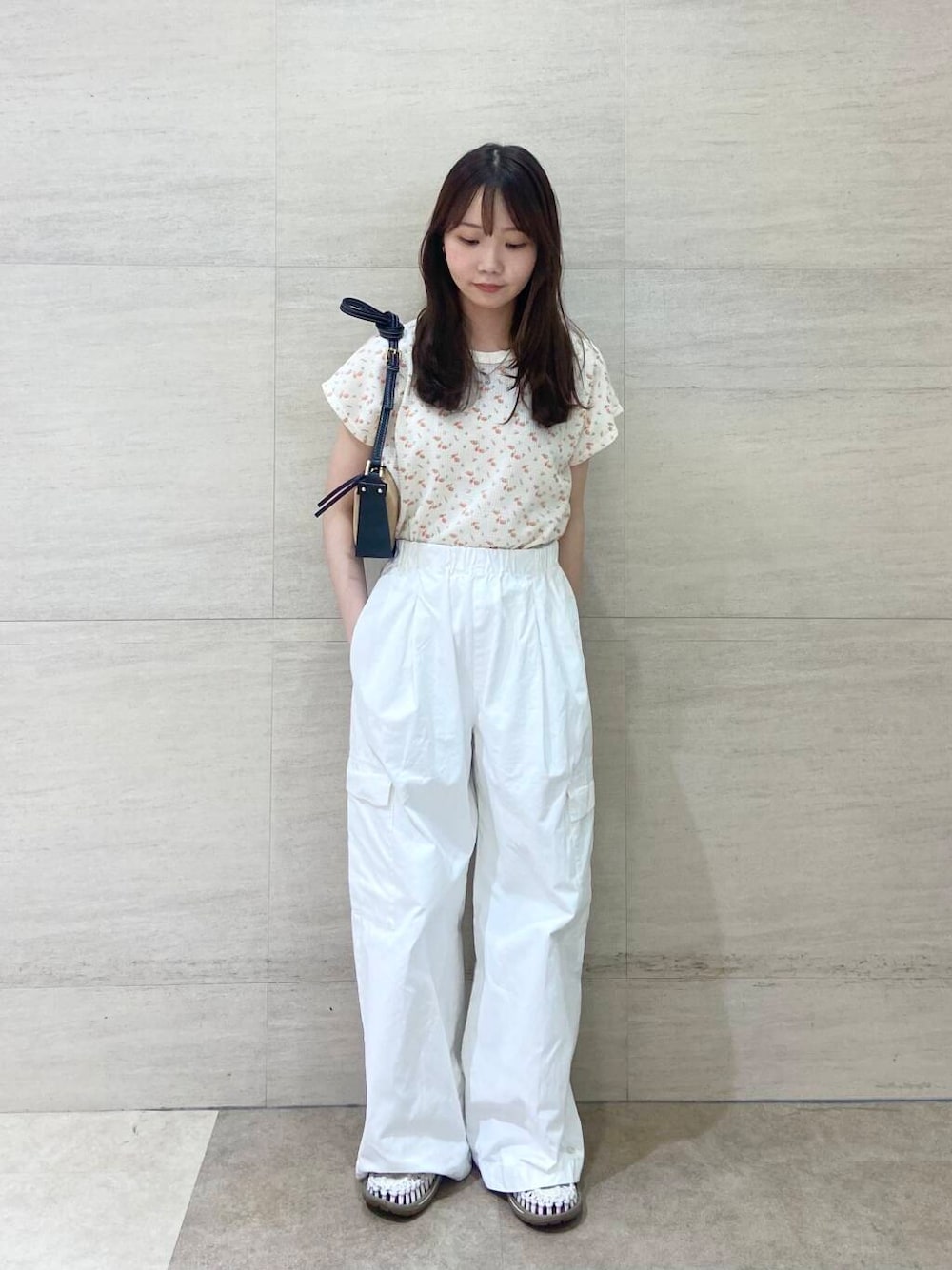 ブラック系のショルダーバッグ、ホワイト系のTシャツ/カットソー、ホワイト系のその他パンツを着用したレディースの春コーディネートの1枚目の写真