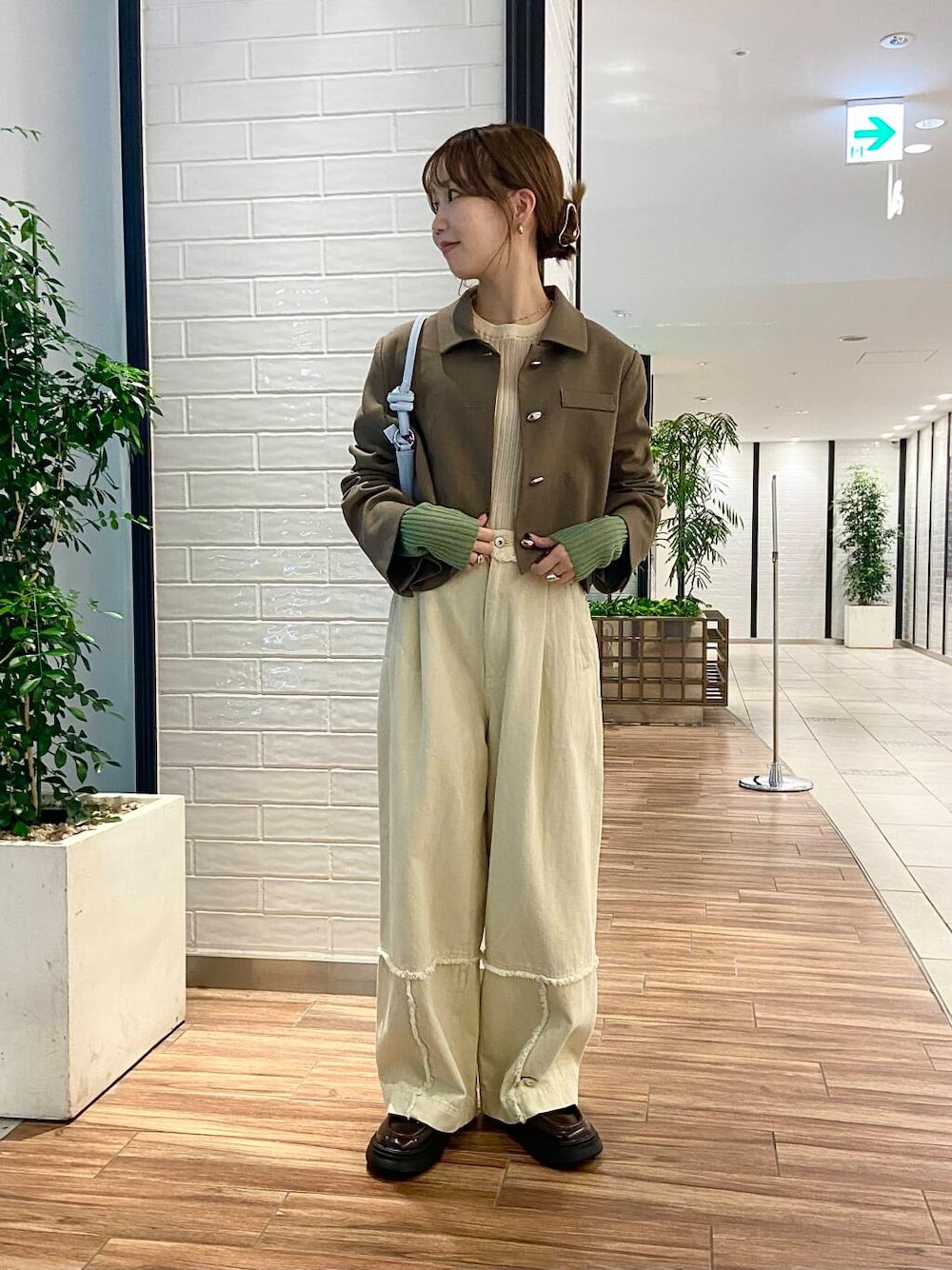 ブルー系のショルダーバッグ、ブラウン系のローファー、ホワイト系のその他パンツを着用したレディースの秋コーディネートの1枚目の写真