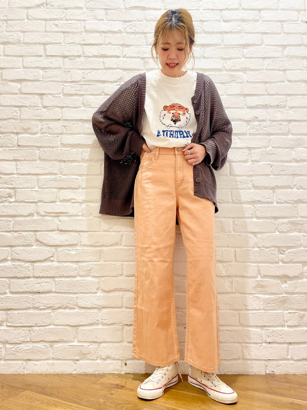 ホワイト系のTシャツ/カットソー、グレー系のカーディガン/ボレロ、オレンジ系のデニムパンツを着用したレディースの春コーディネートの1枚目の写真