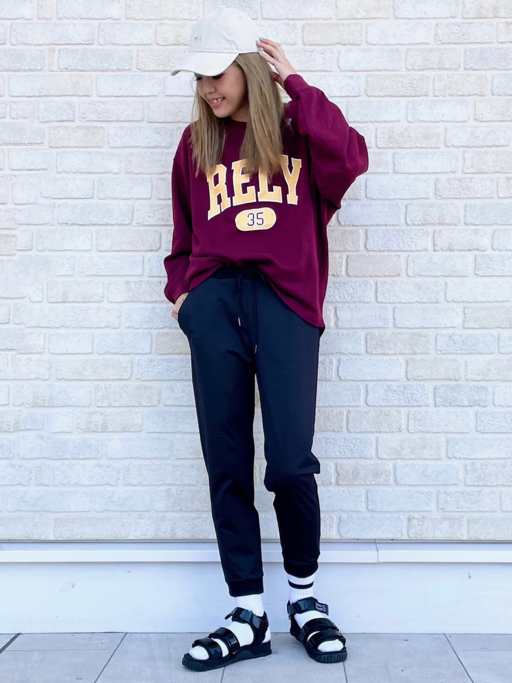 レッド系のスウェット、ブラック系のその他パンツ、ブラック系のサンダルを着用したレディースの秋コーディネートの1枚目の写真