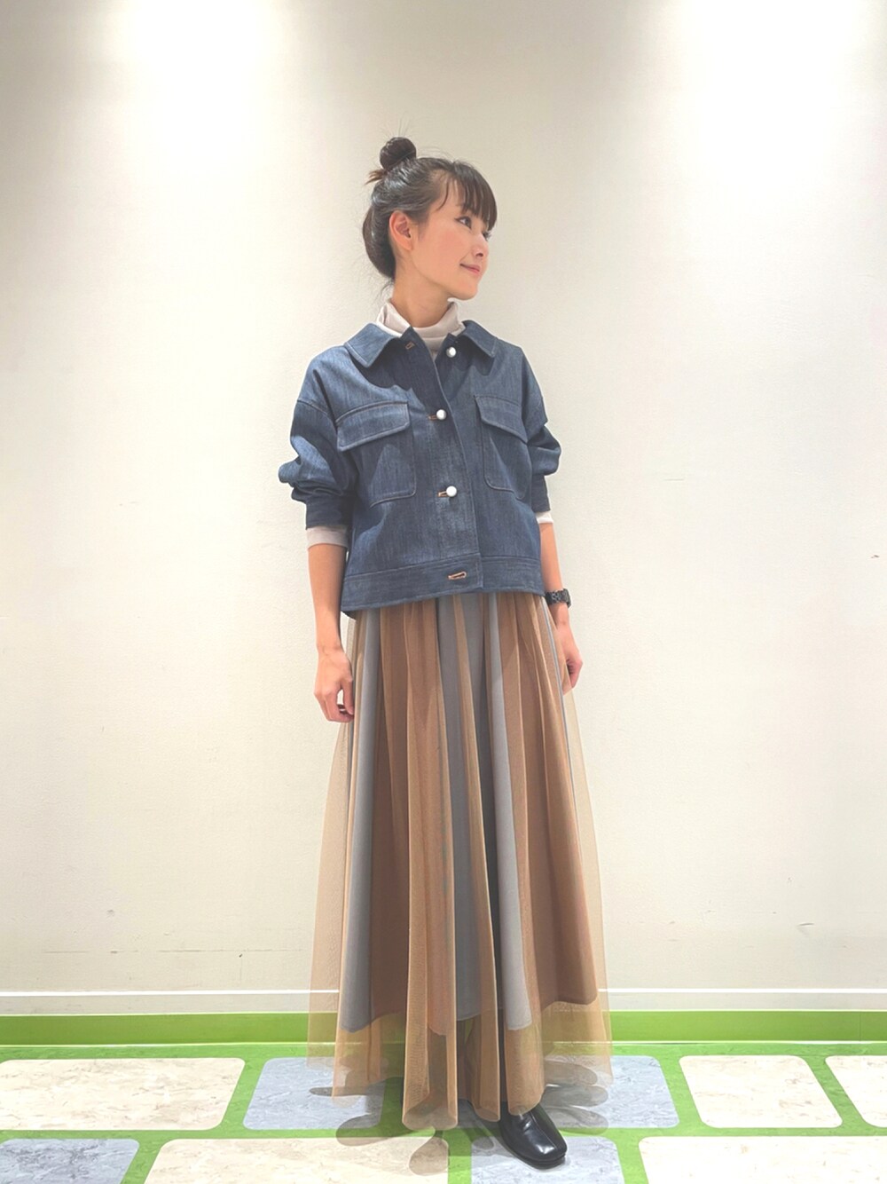 ブラウン系のスカート、ブルー系のデニムジャケットを着用したレディースの秋コーディネートの1枚目の写真
