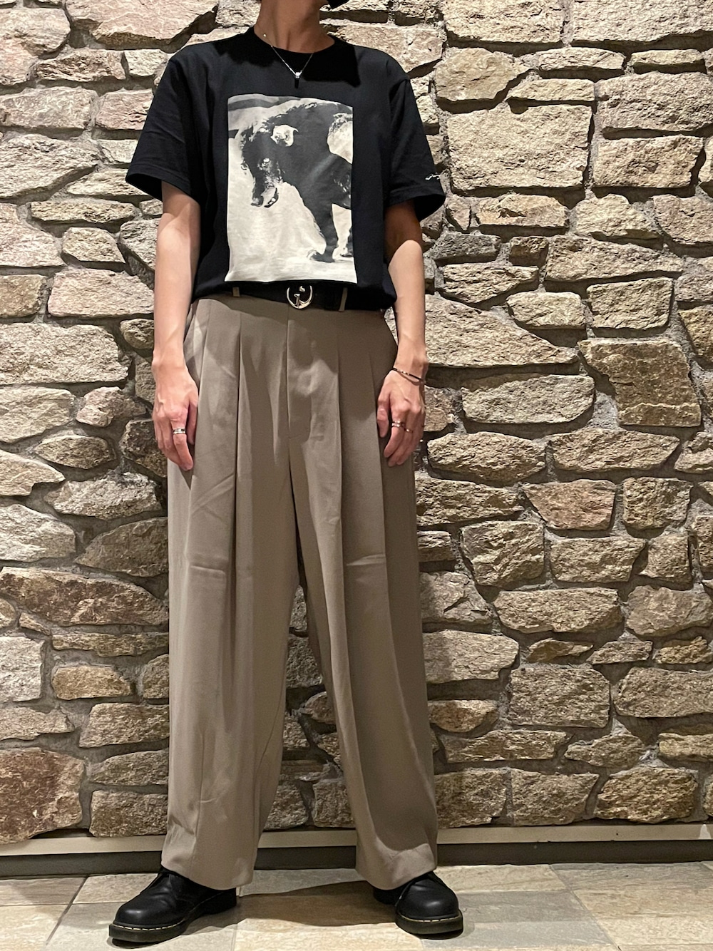 ブラック系のTシャツ/カットソー、ベージュ系のスラックス、ブラック系のローファーを着用したメンズの夏コーディネートの1枚目の写真