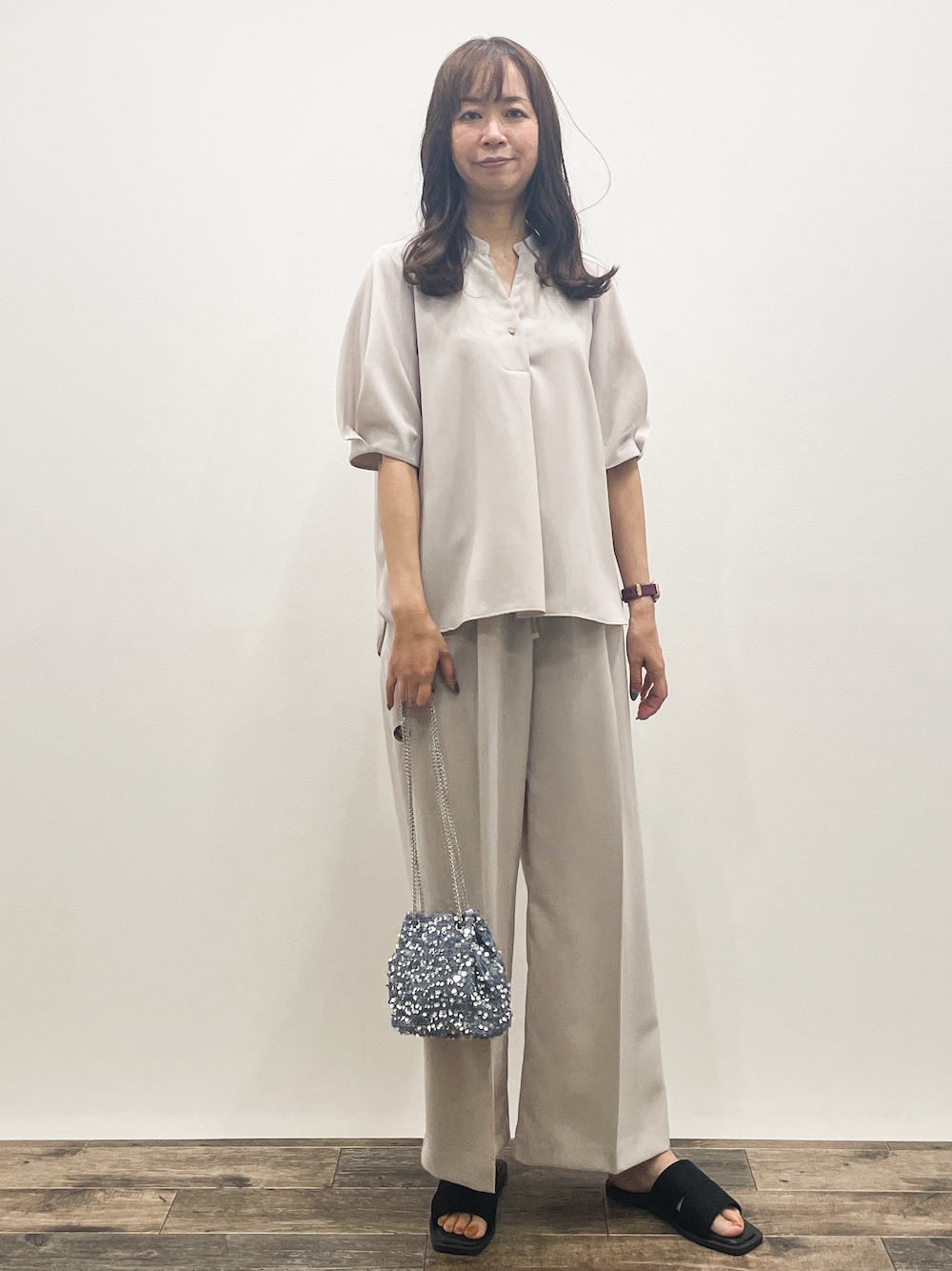 ベージュ系のシャツ/ブラウス、ベージュ系のその他パンツ、グレー系のショルダーバッグを着用したレディースの春コーディネートの1枚目の写真
