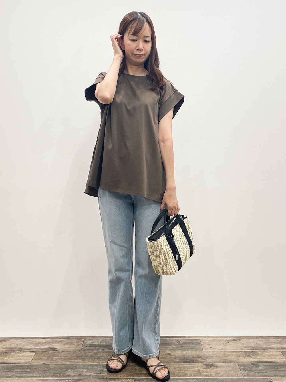 ブラウン系のTシャツ/カットソー、ブルー系のデニムパンツ、ブラック系のトートバッグを着用したレディースの夏コーディネートの1枚目の写真