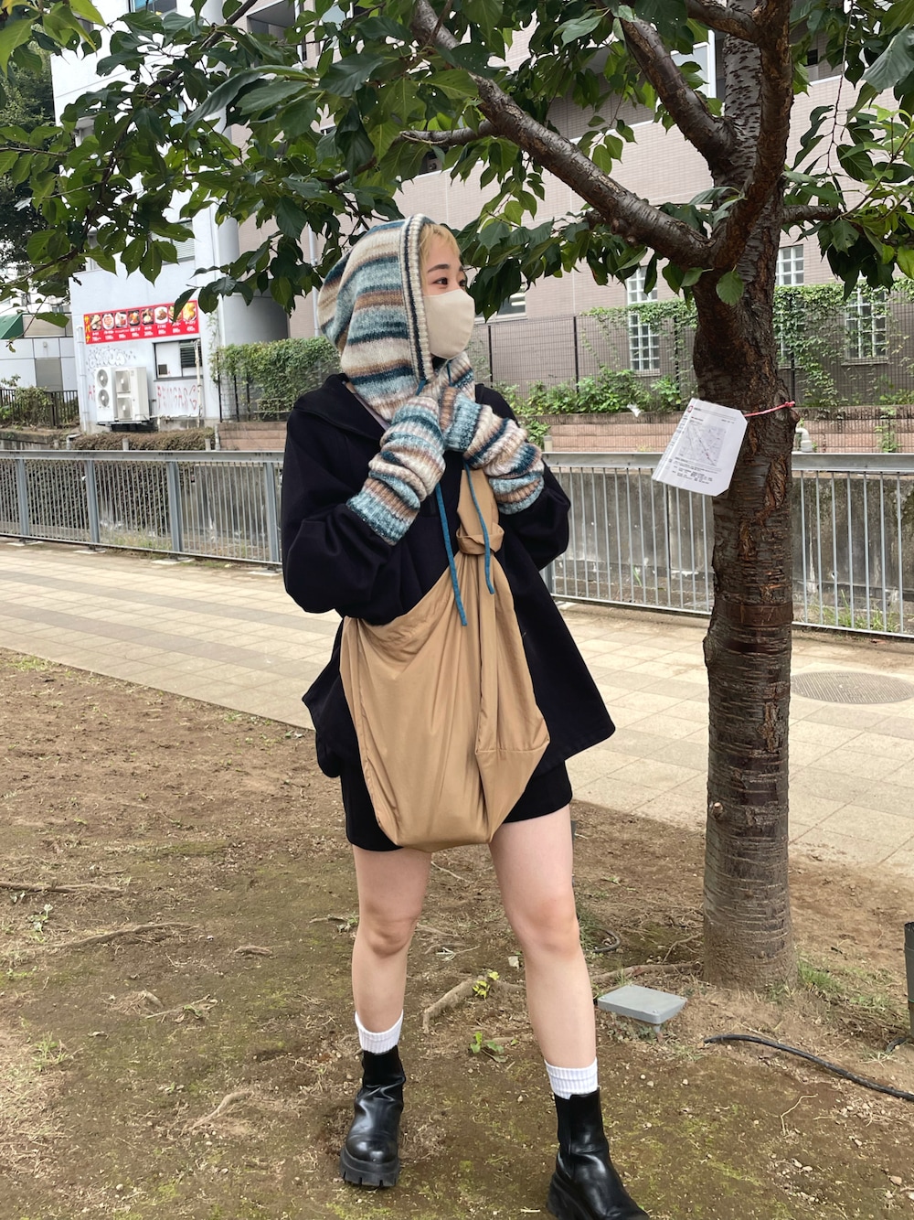 ベージュ系のショルダーバッグ、ブルー系のニット/セーターを着用したレディースの秋コーディネートの1枚目の写真