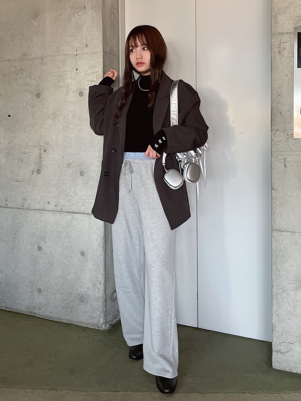 グレー系のスウェットパンツ、ブラック系のニット/セーター、グレー系のテーラードジャケットを着用したレディースの冬コーディネートの1枚目の写真