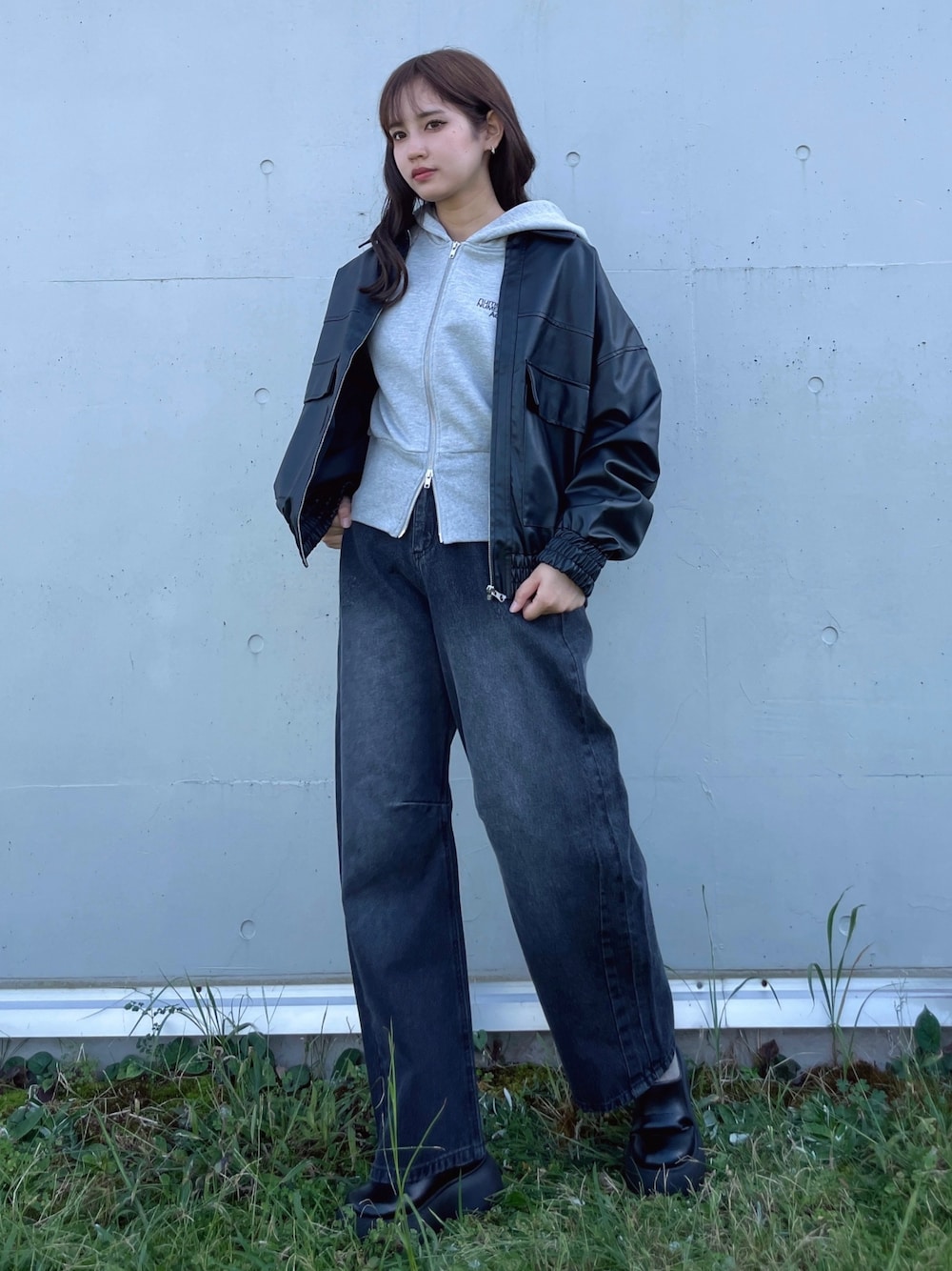 ブラック系のデニムパンツ、ブラック系のサンダル、グレー系のパーカーを着用したレディースの秋コーディネートの1枚目の写真