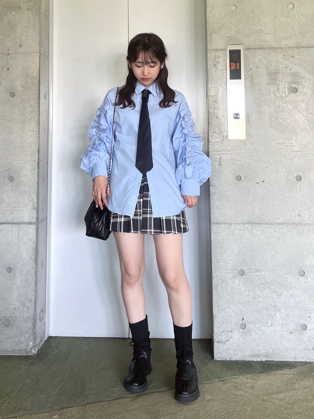 グレー系のシャツ/ブラウス、グレー系のスカート、ブルー系のシャツ/ブラウスを着用したレディースの秋コーディネートの1枚目の写真