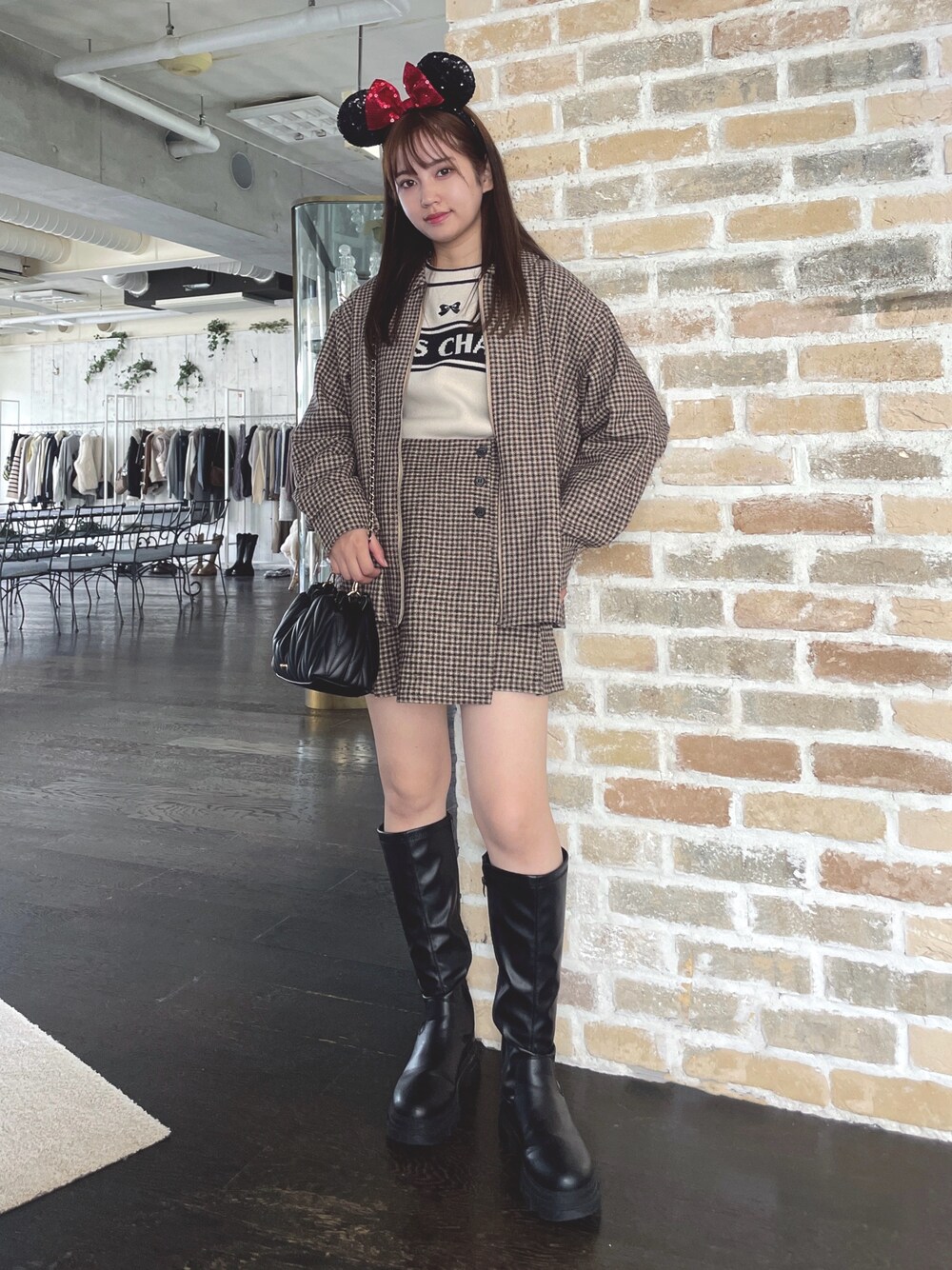 ブラック系のショルダーバッグ、ブラック系のブーツ、ホワイト系のニット/セーターを着用したレディースの秋コーディネートの1枚目の写真