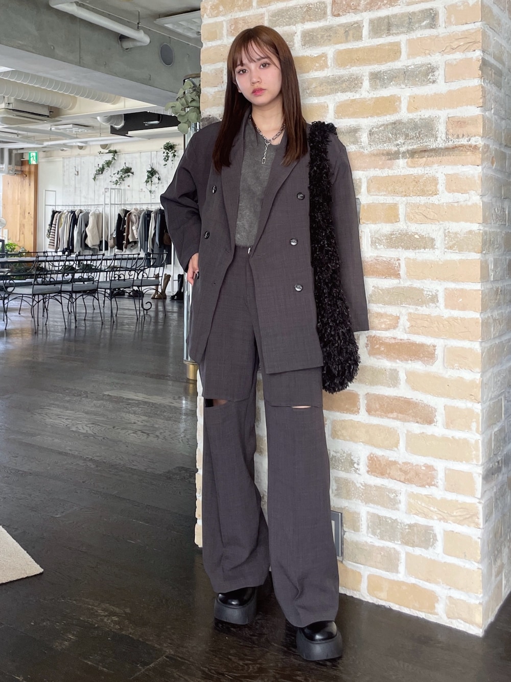 ブラック系のショルダーバッグ、グレー系のスラックス、ブラック系のサンダルを着用したレディースの秋コーディネートの1枚目の写真