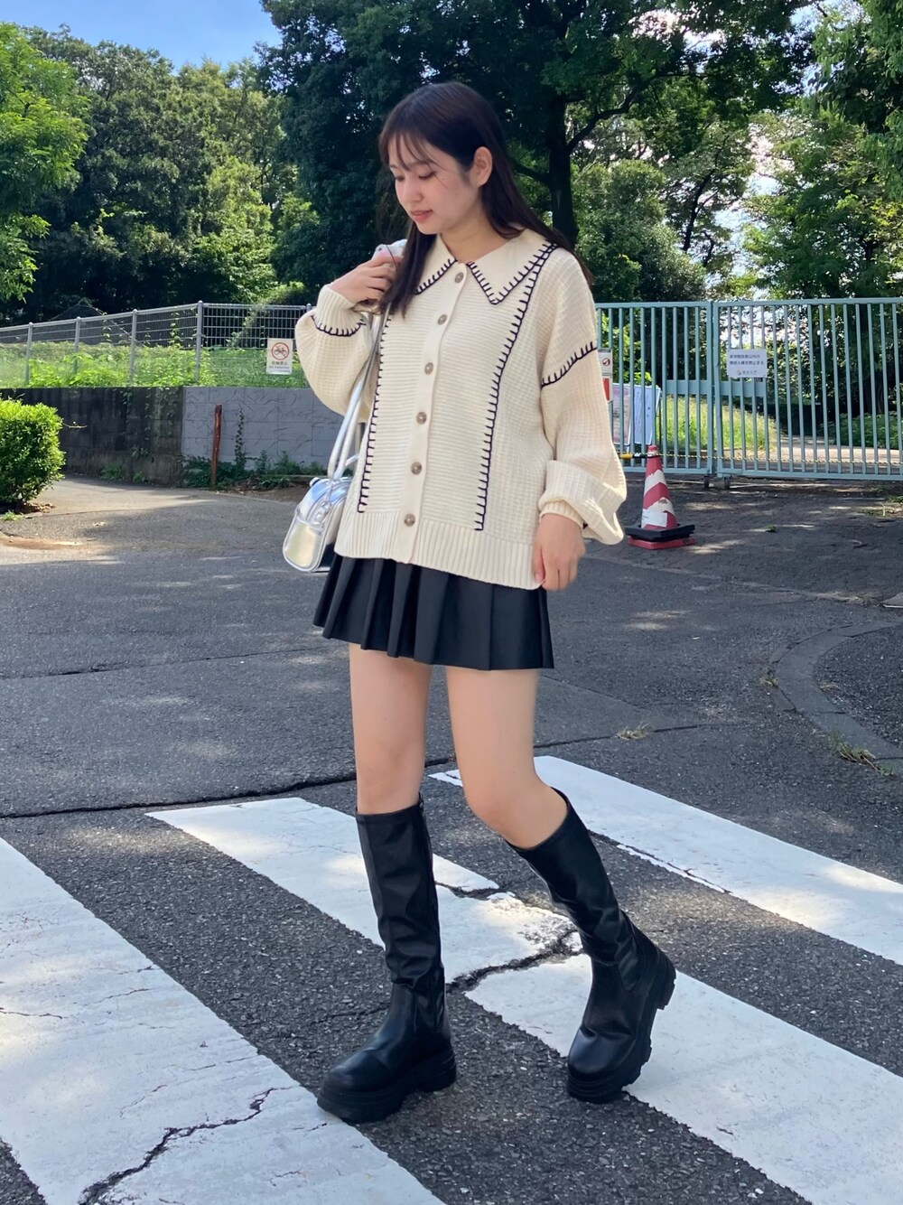 ブラック系のスカート、ブラック系のブーツ、ベージュ系のカーディガン/ボレロを着用したレディースの秋コーディネートの1枚目の写真
