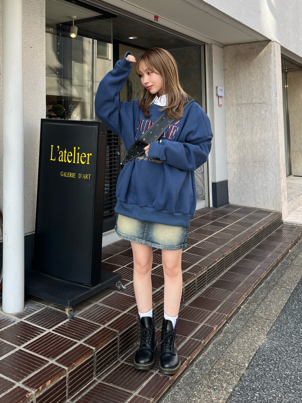 ブルー系のスウェット、ホワイト系のシャツ/ブラウス、ブルー系のデニムスカートを着用したレディースの秋コーディネートの1枚目の写真