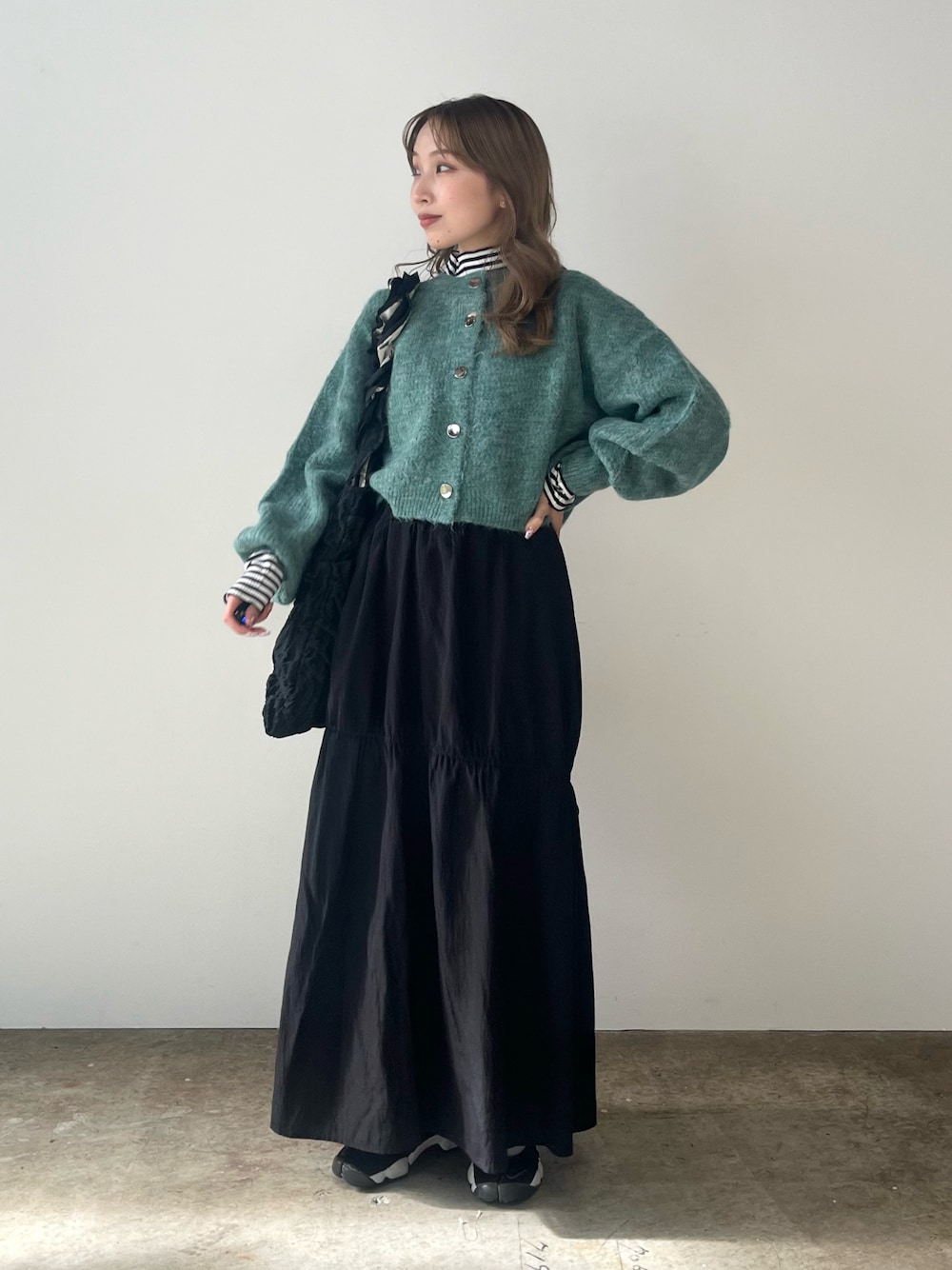 グリーン系のカーディガン/ボレロ、その他のTシャツ/カットソー、ブラック系のトートバッグを着用したレディースの秋コーディネートの1枚目の写真