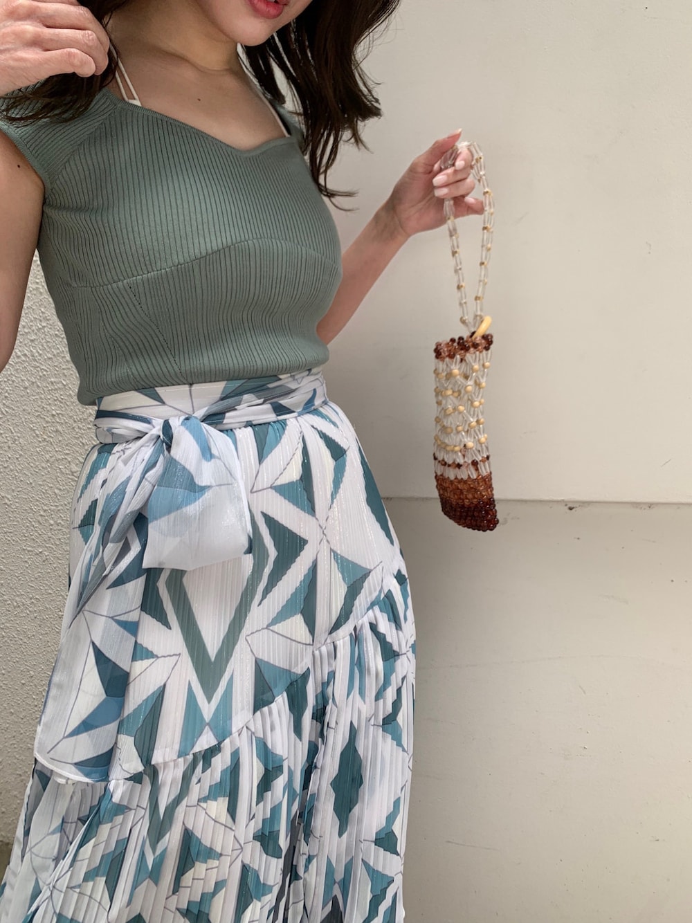 グリーン系のサンダル、ブルー系のスカート、グリーン系のニット/セーターを着用したレディースの春コーディネートの1枚目の写真