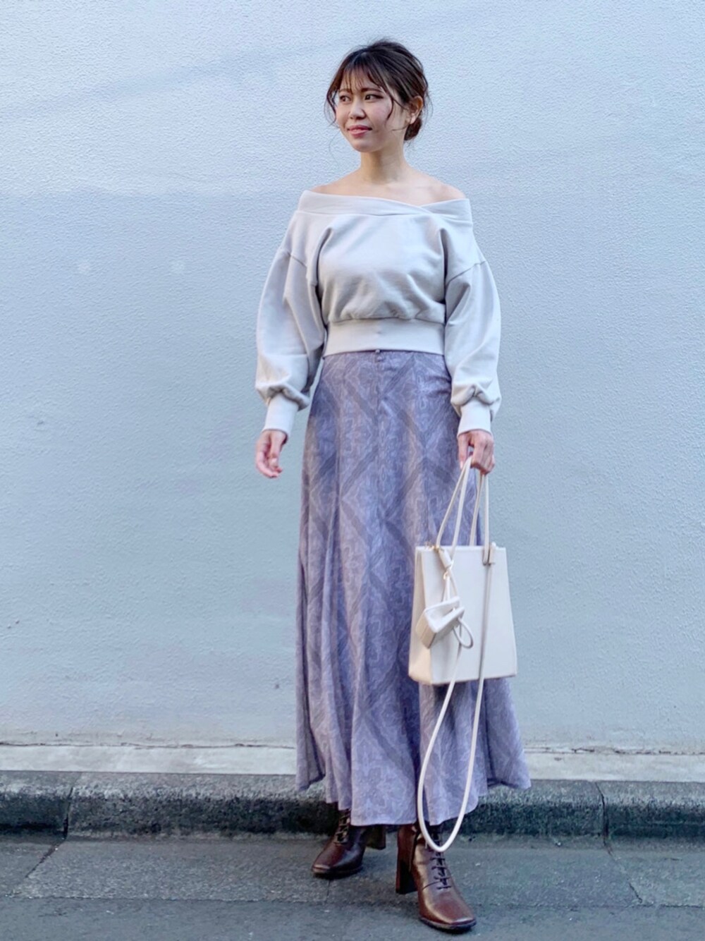 パープル系のスカート、ベージュ系のトートバッグ、ベージュ系のTシャツ/カットソーを着用したレディースの冬コーディネートの1枚目の写真