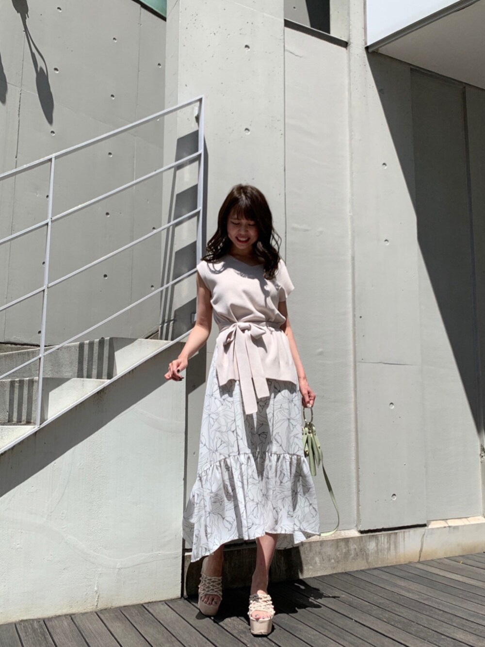 グリーン系のショルダーバッグ、ホワイト系のサンダル、ホワイト系のワンピースを着用したレディースの春コーディネートの1枚目の写真