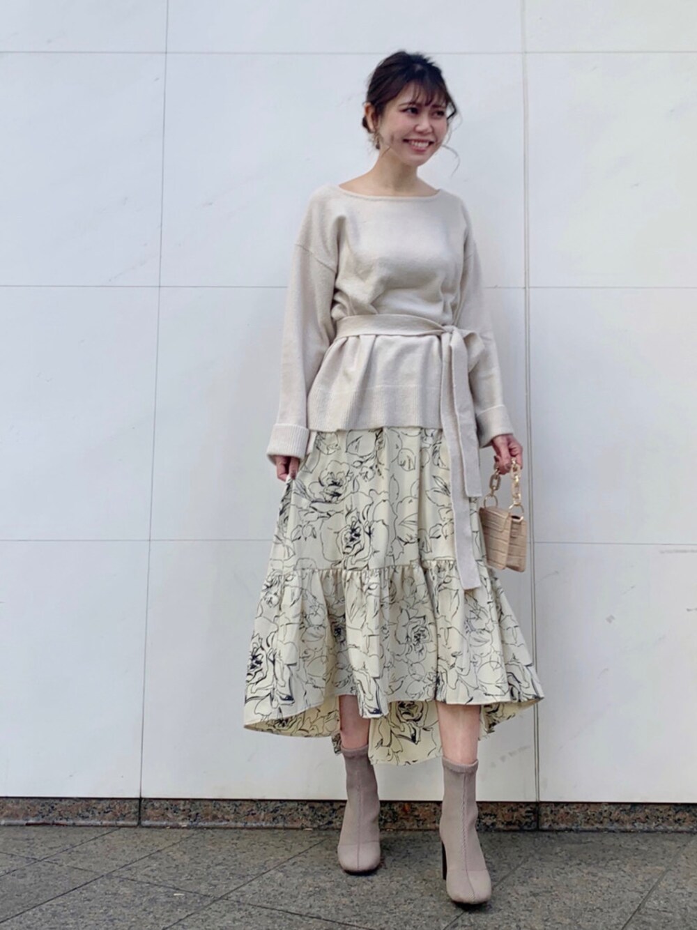 ベージュ系のハンドバッグを着用したレディースの冬コーディネートの1枚目の写真