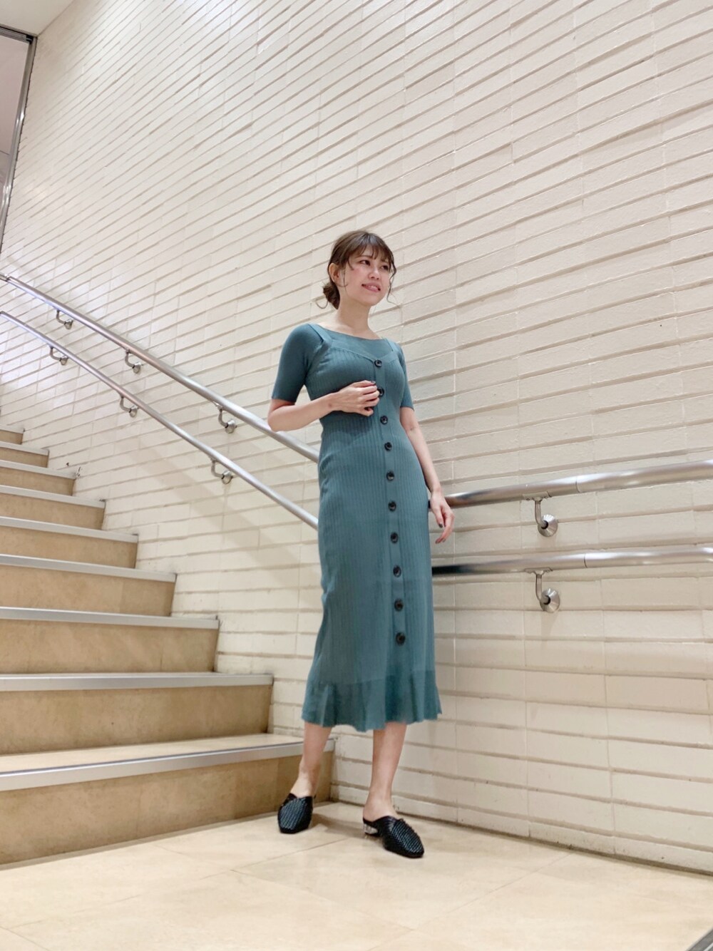 グリーン系のワンピース、ブラック系のサンダルを着用したレディースの春コーディネートの1枚目の写真