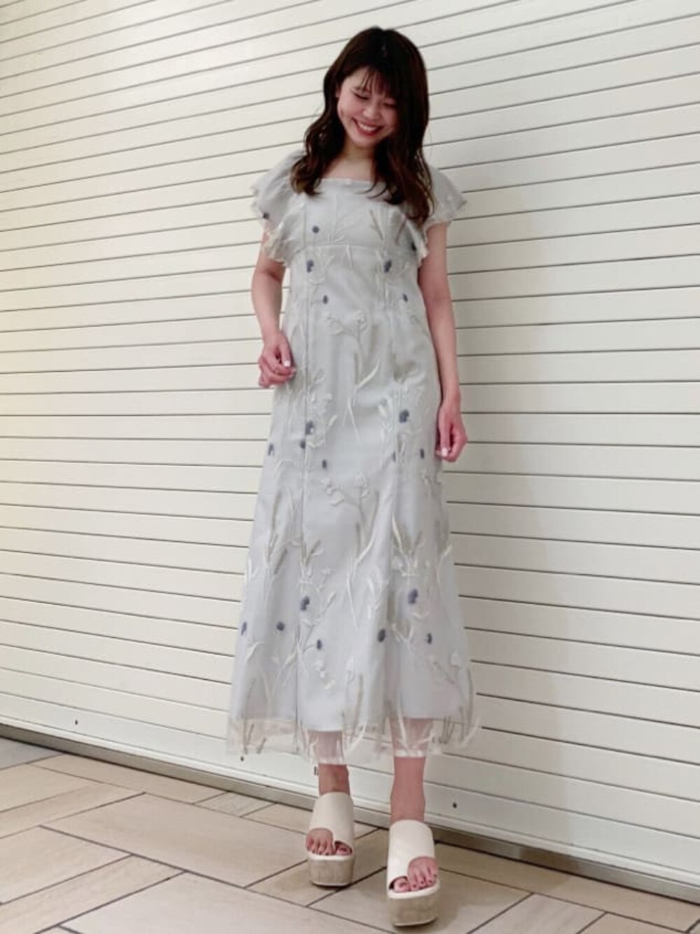 グリーン系のワンピース、ホワイト系のサンダルを着用したレディースの夏コーディネートの1枚目の写真