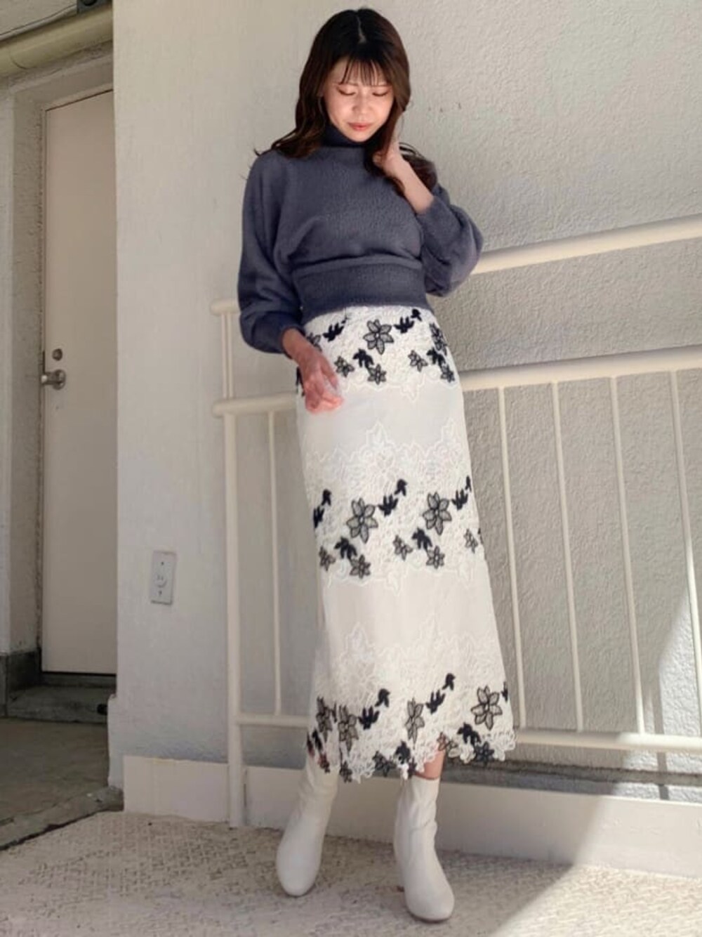 ホワイト系のその他シューズ、ホワイト系のスカート、ブルー系のニット/セーターを着用したレディースの秋コーディネートの1枚目の写真