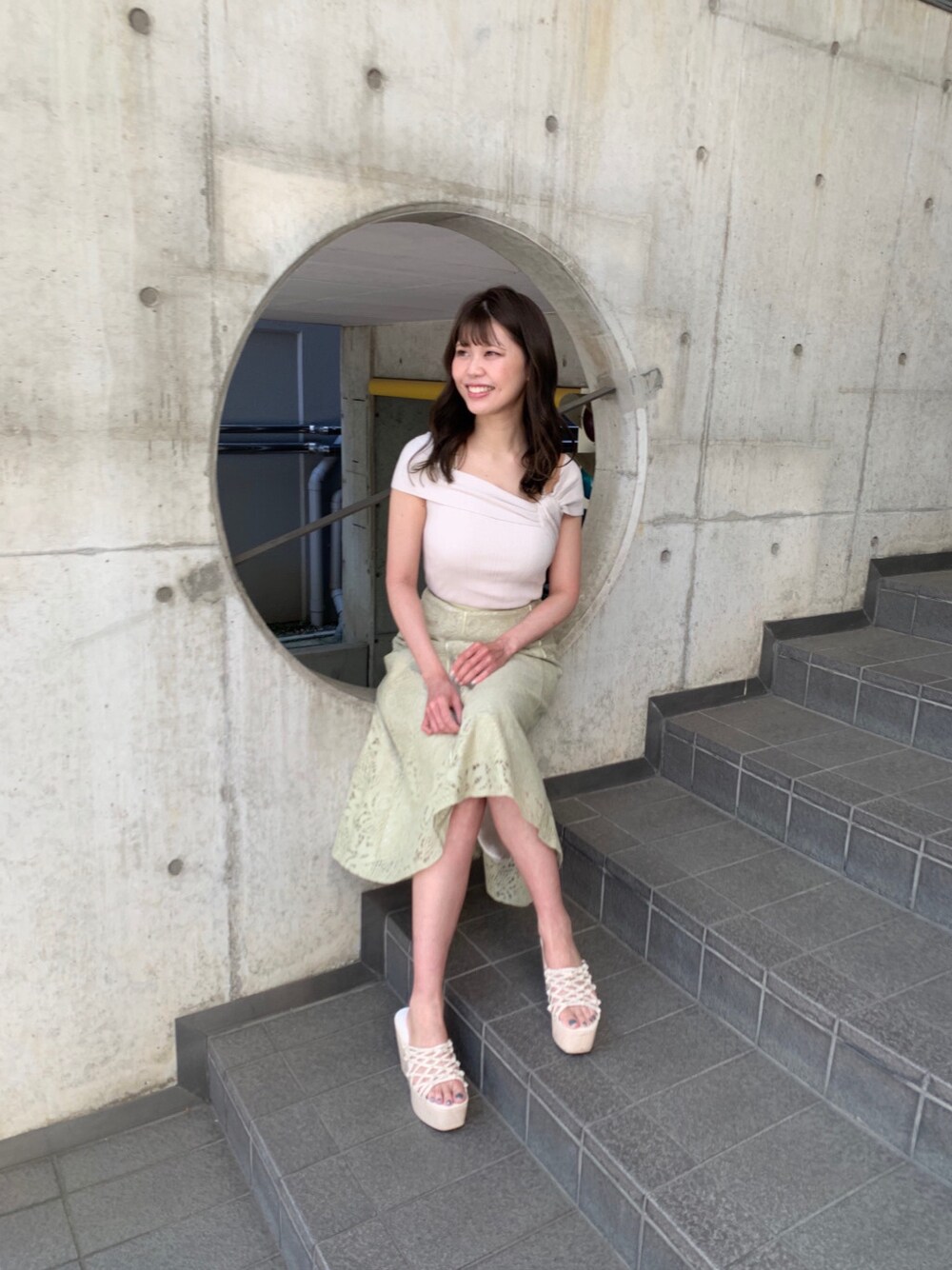 ホワイト系のサンダル、イエロー系のスカート、ホワイト系のニット/セーターを着用したレディースの春コーディネートの1枚目の写真