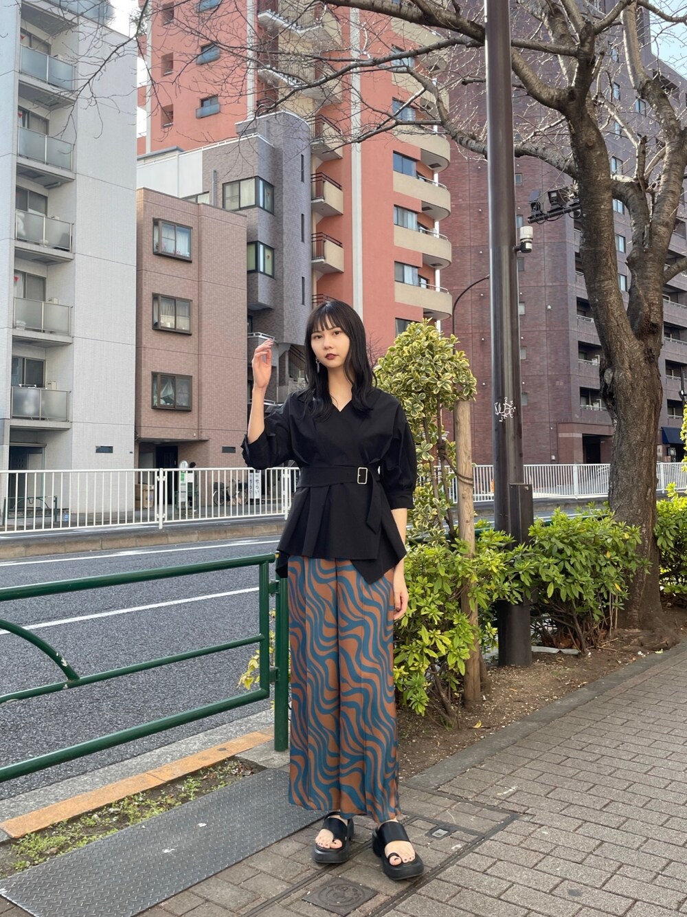 ブラック系のシャツ/ブラウス、ブルー系のスラックス、ブラック系のサンダルを着用したレディースの春コーディネートの1枚目の写真