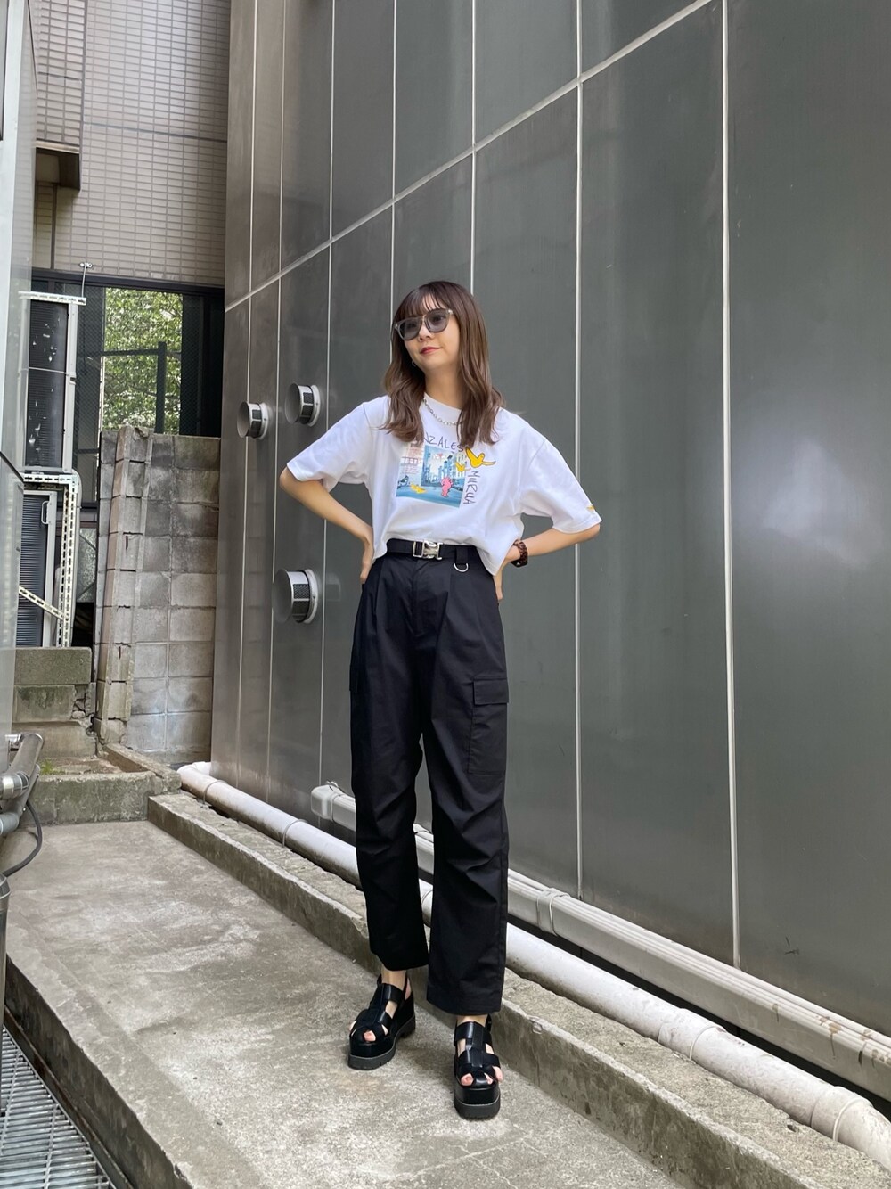 ホワイト系のTシャツ/カットソー、ブラック系のカーゴパンツ、ブラック系のサンダルを着用したレディースの春コーディネートの1枚目の写真